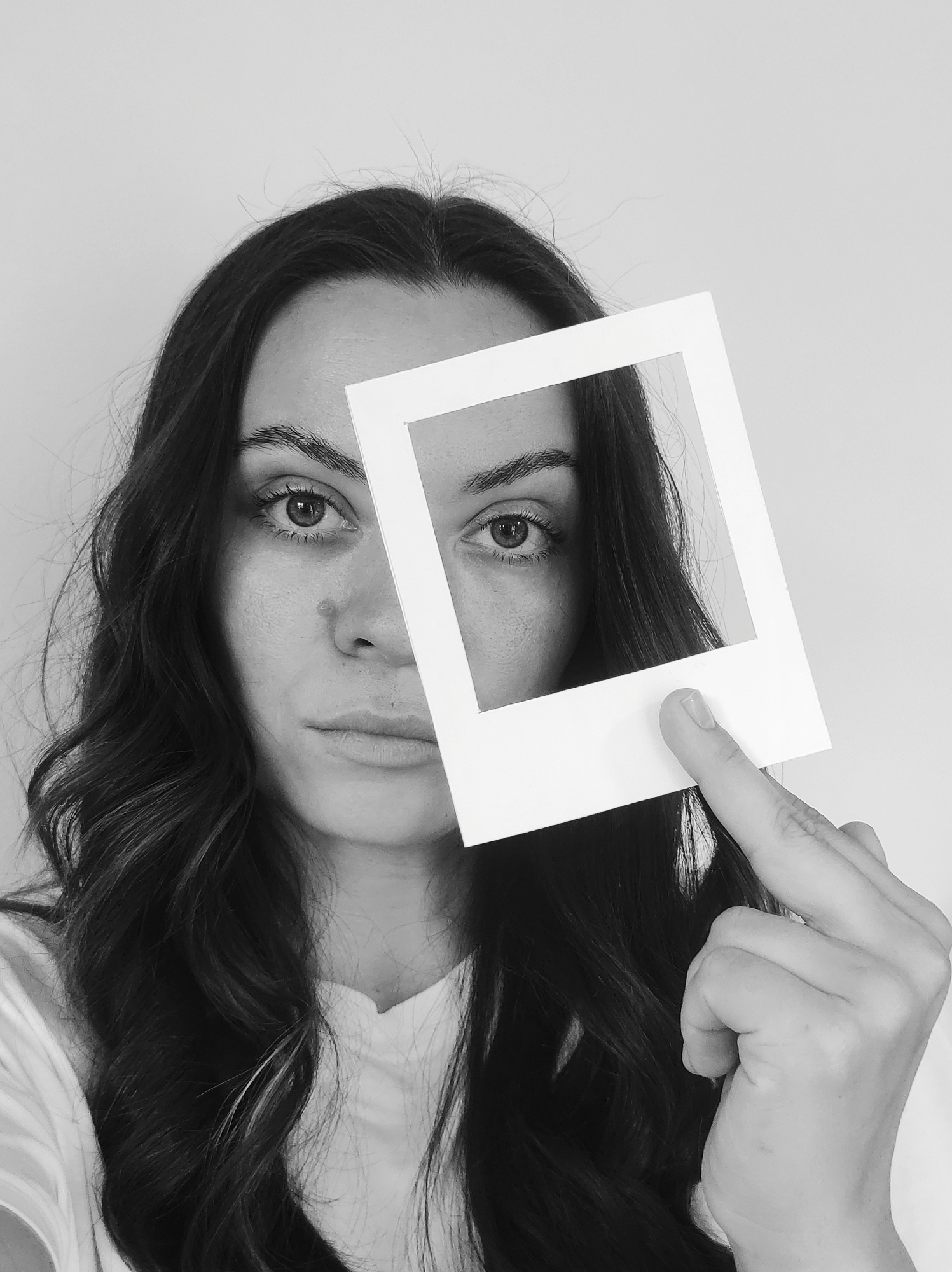 Woman photographed in artistic close-up portrait session with frame prop