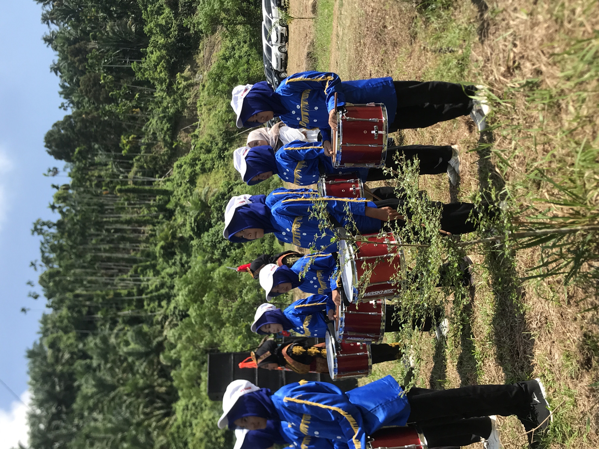 Marching band performs drumline routine at outdoor event in Langkuta