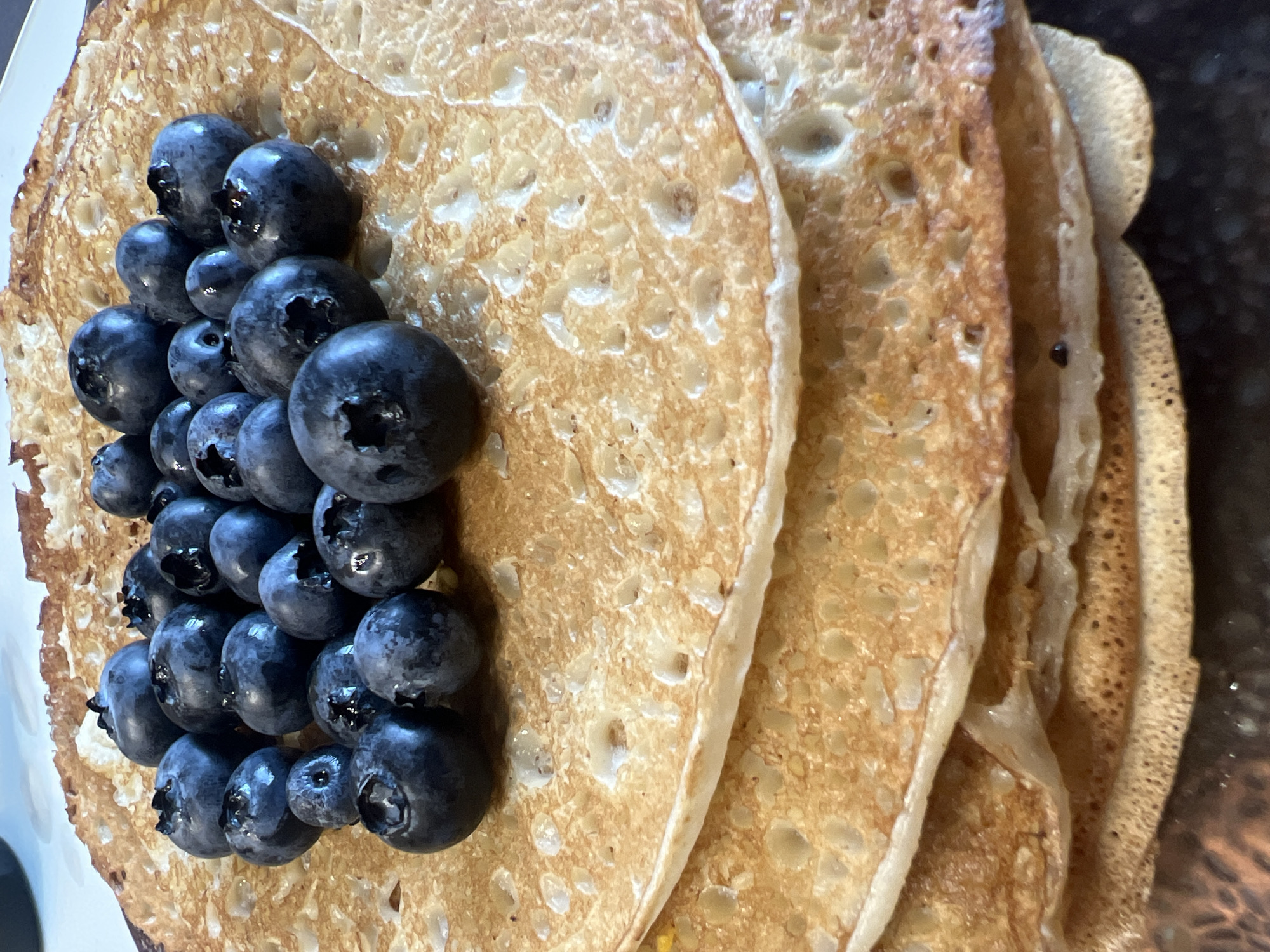 Golden crepes and fresh blueberries, up close