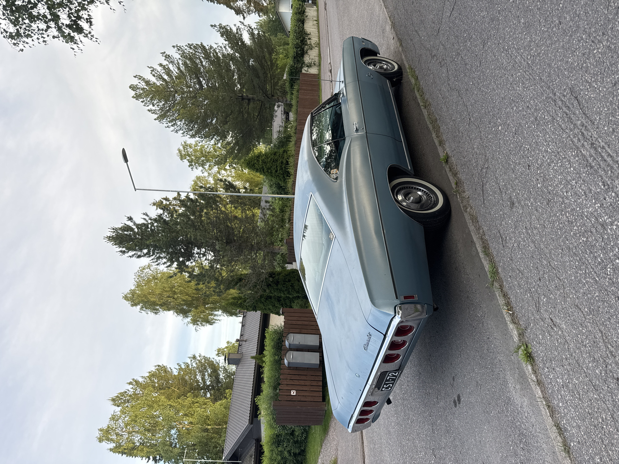 Strolling a quiet residential street with a vintage Chevy parked nearby