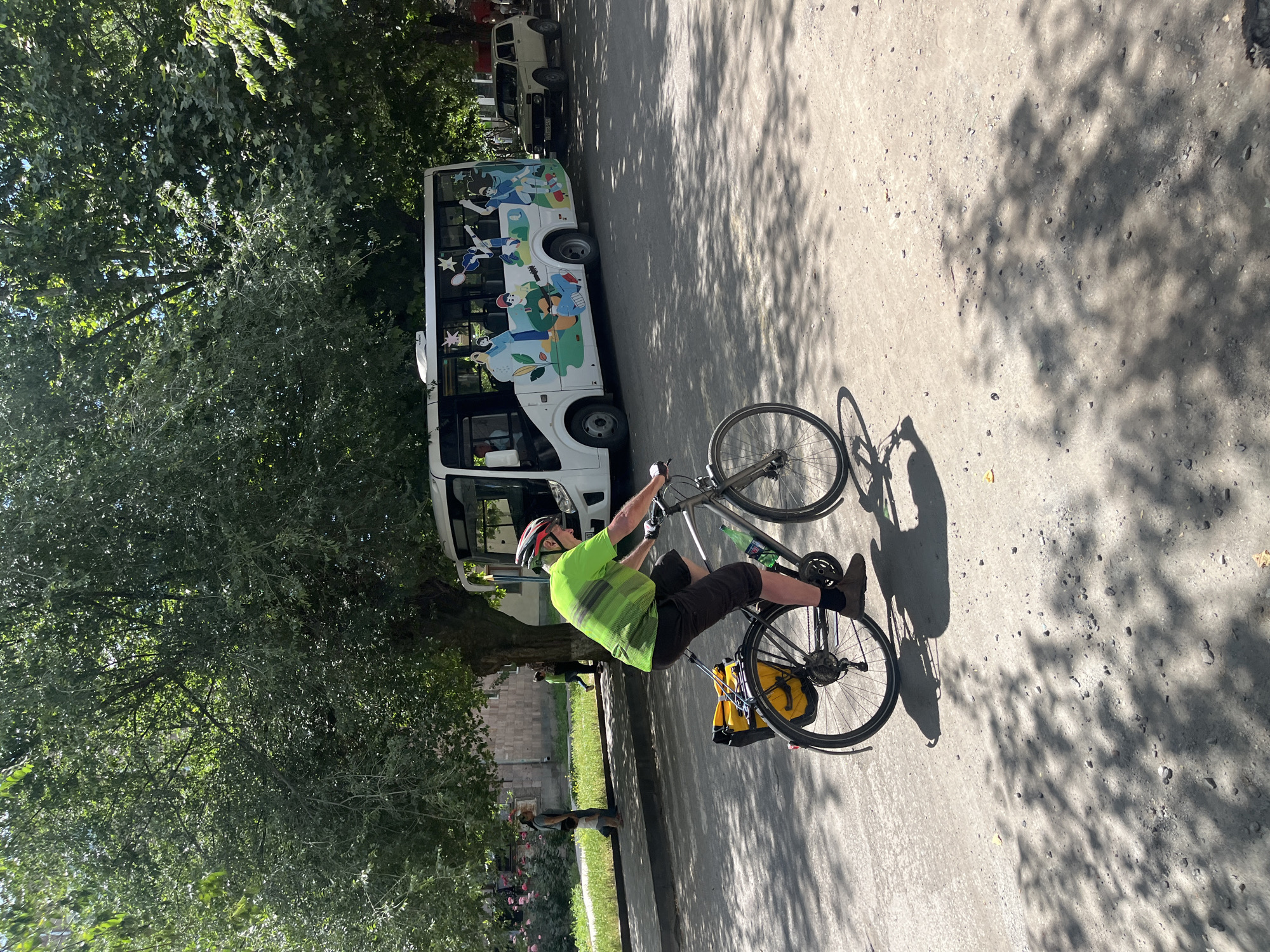 Cyclist and parked gold Nissan on a quiet urban street