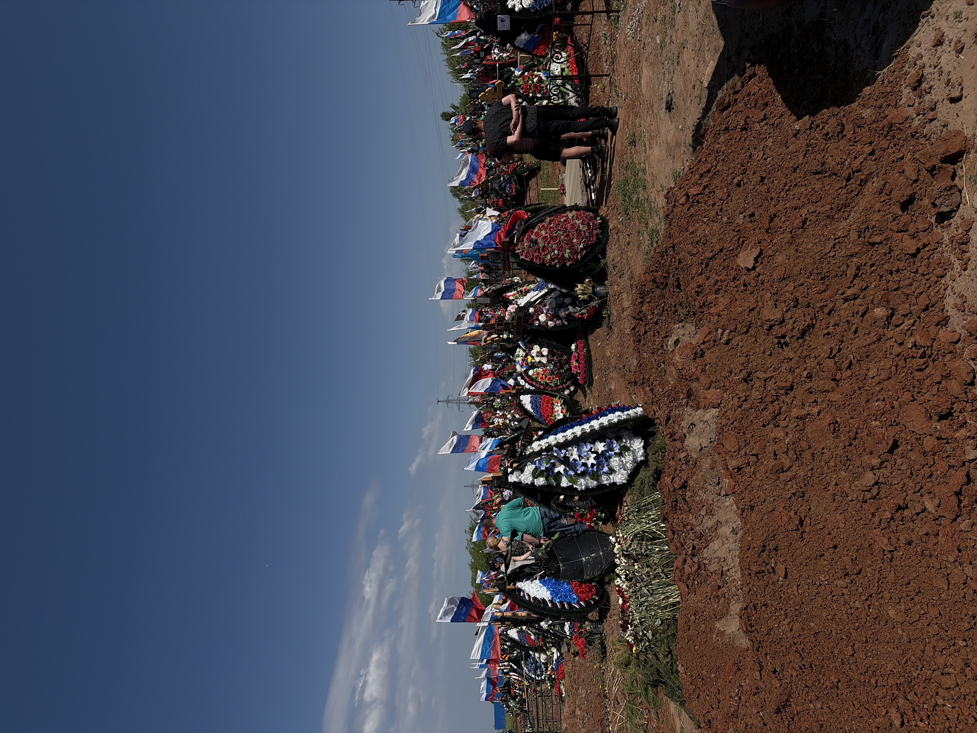 Memorial gathering observed at Izhevsk cemetery with flags, wreaths