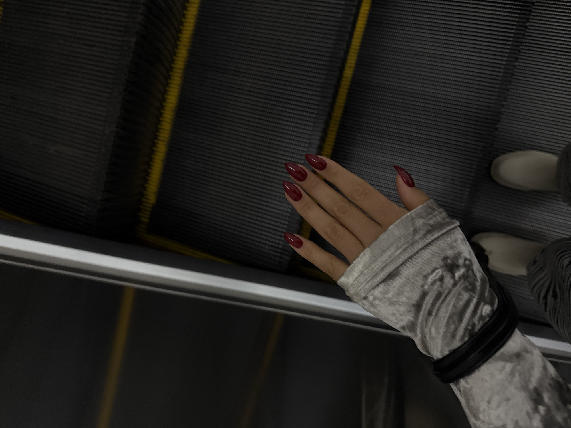 Person with burgundy nails rides escalator in Yerevan