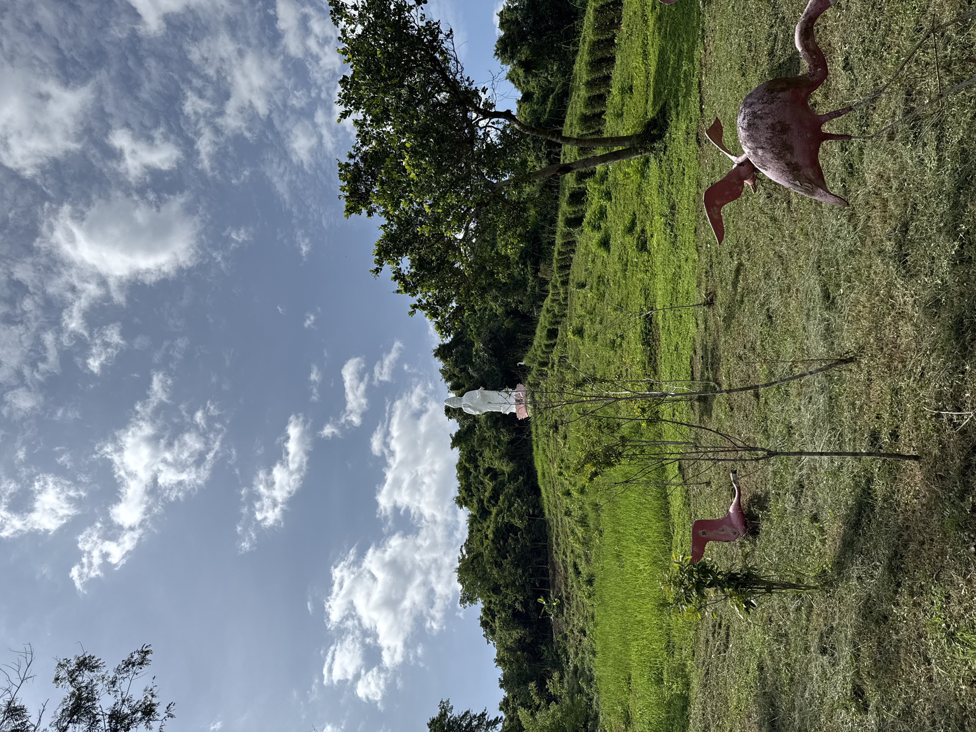 White deity statue overlooks green hills in Khanh Vinh