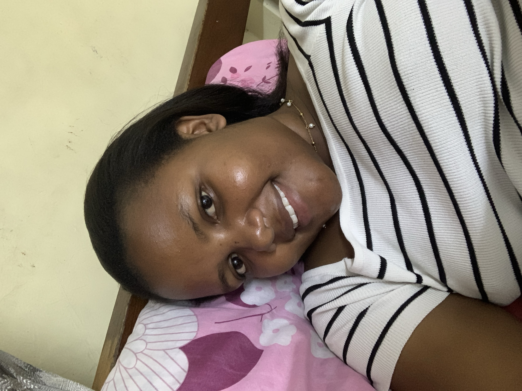 Woman rests on floral pillow in Dar es Salaam bedroom