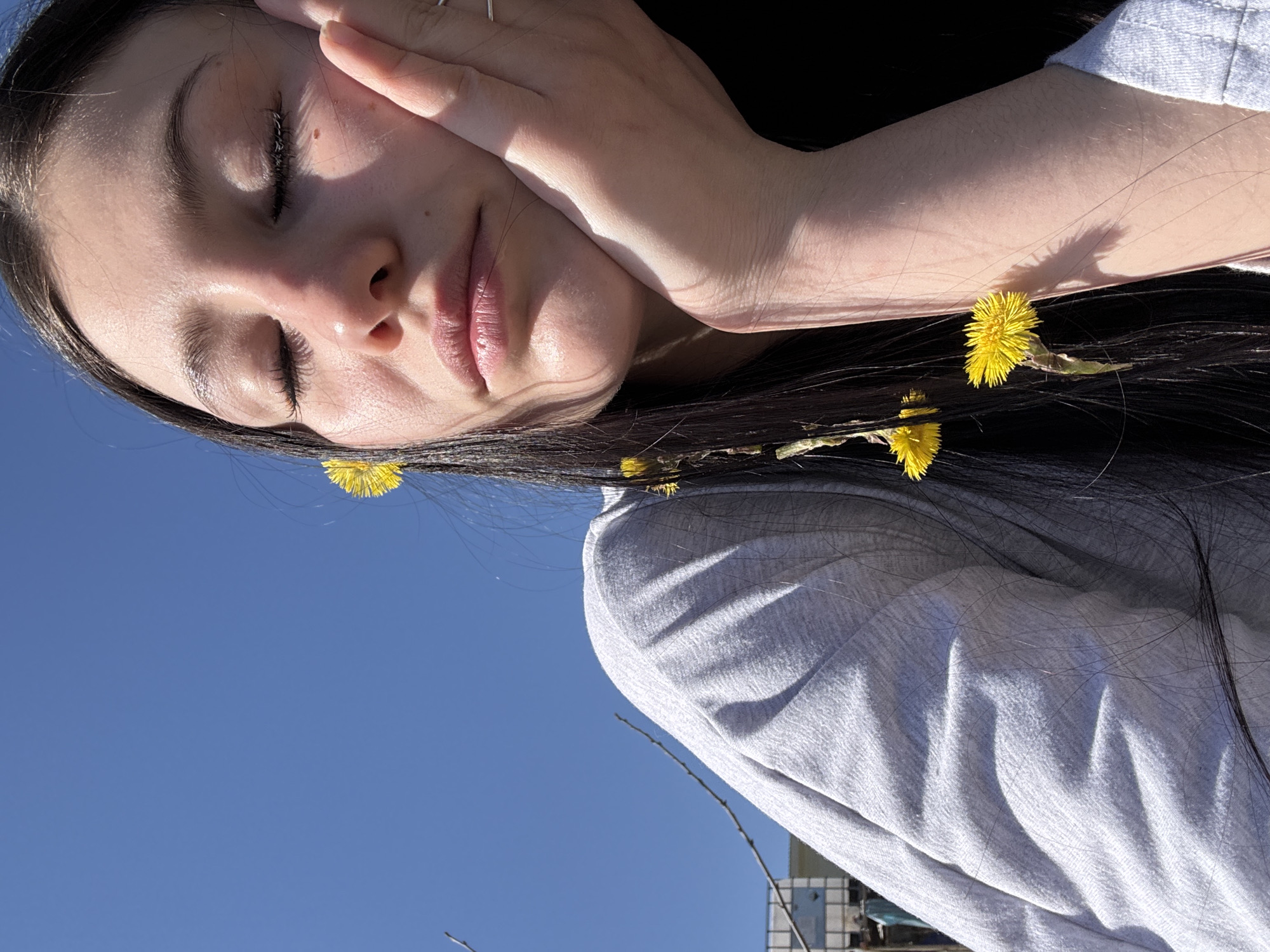 Woman documents sunny spring morning with flower selfies in Фоки