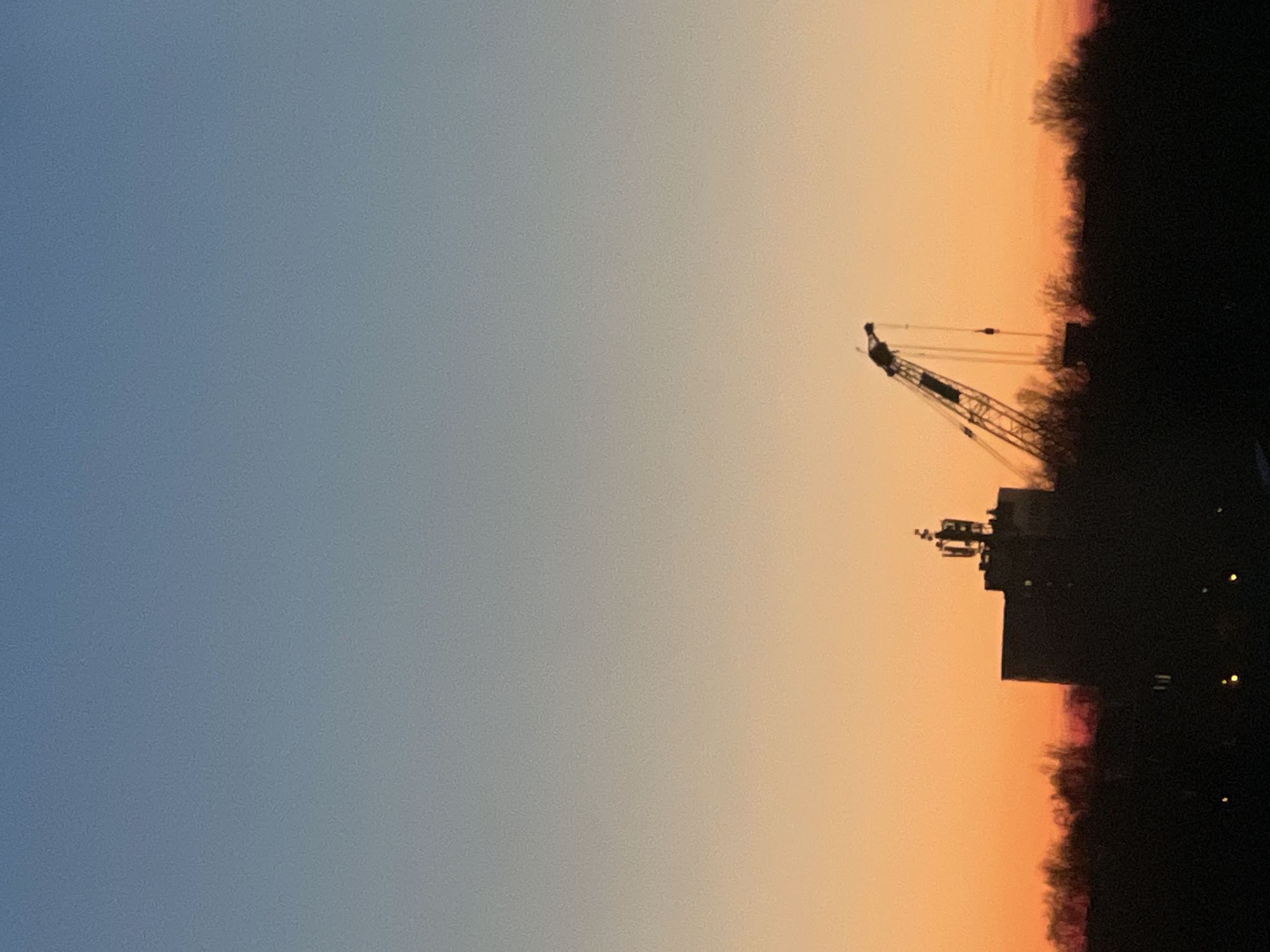 Construction crane silhouetted against sunset sky in Saint Petersburg