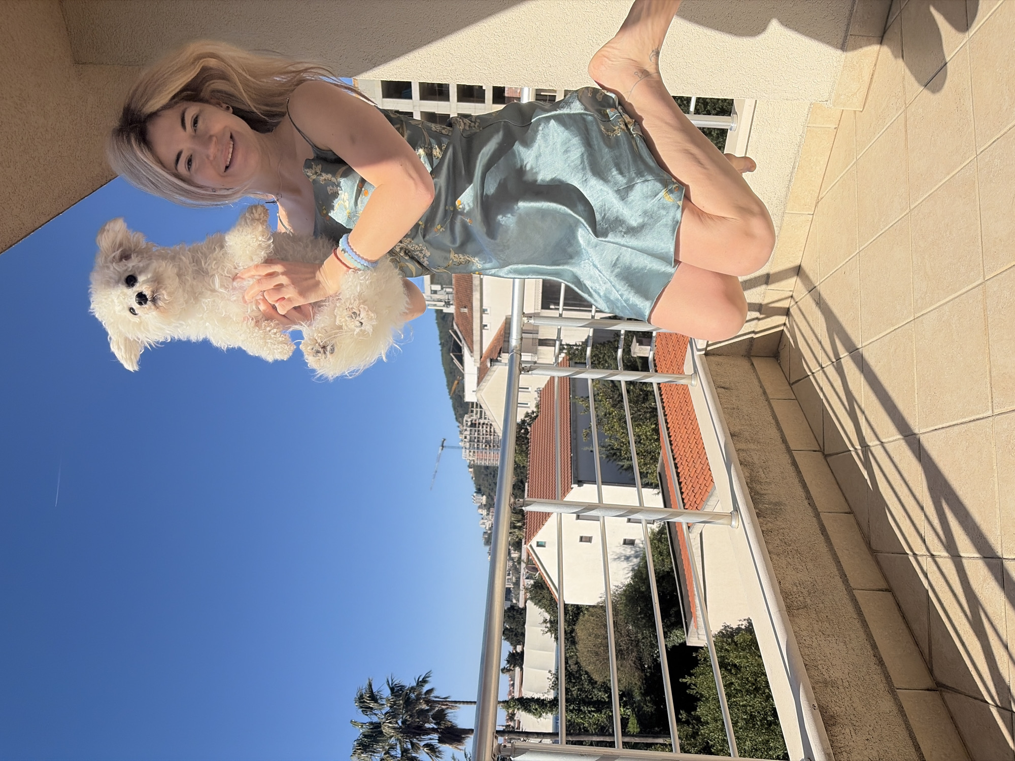Woman with dog enjoys morning moment on Budva balcony