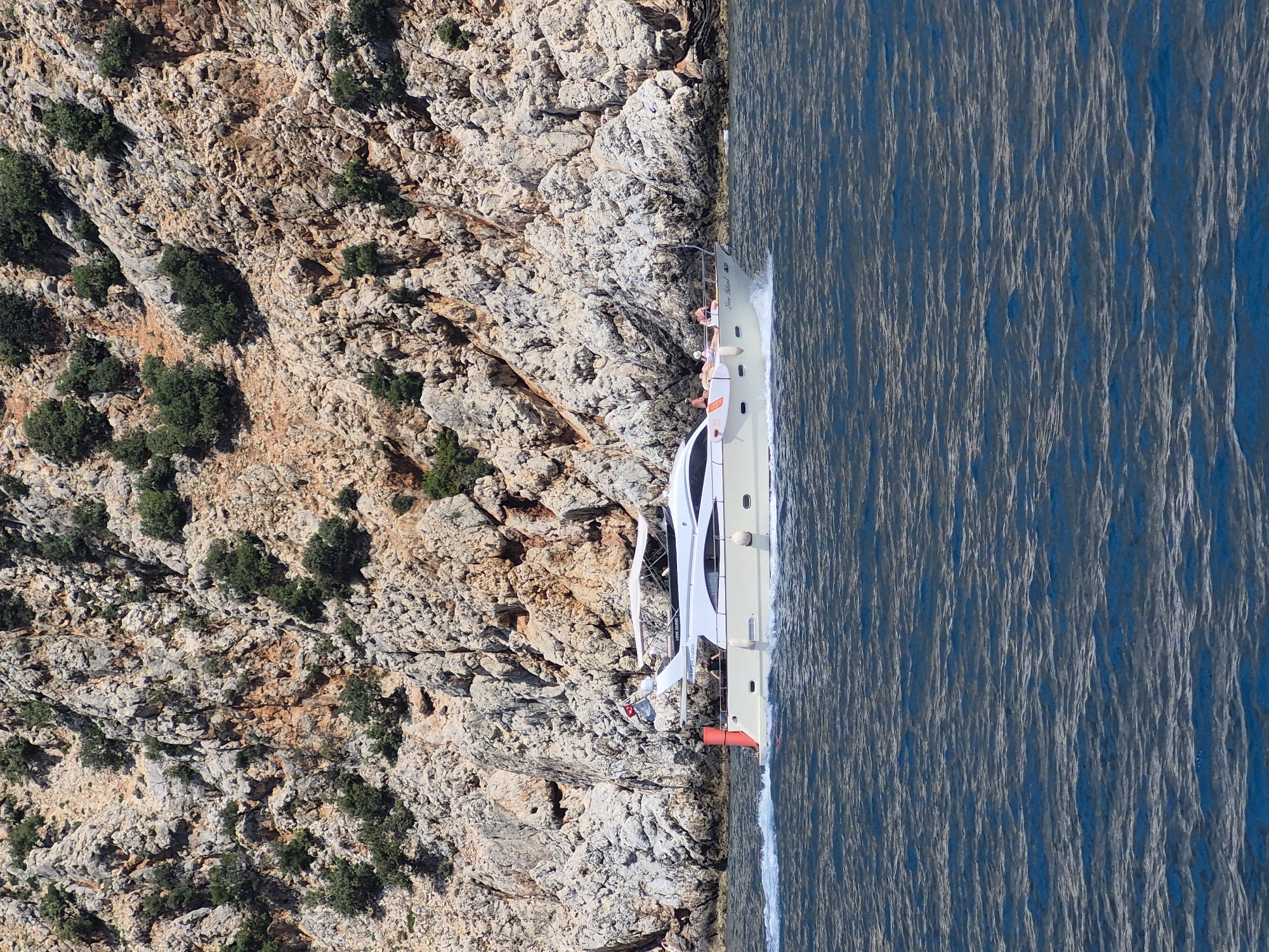 Tourist boat cruises near Alanya Castle cliffs, Turkey