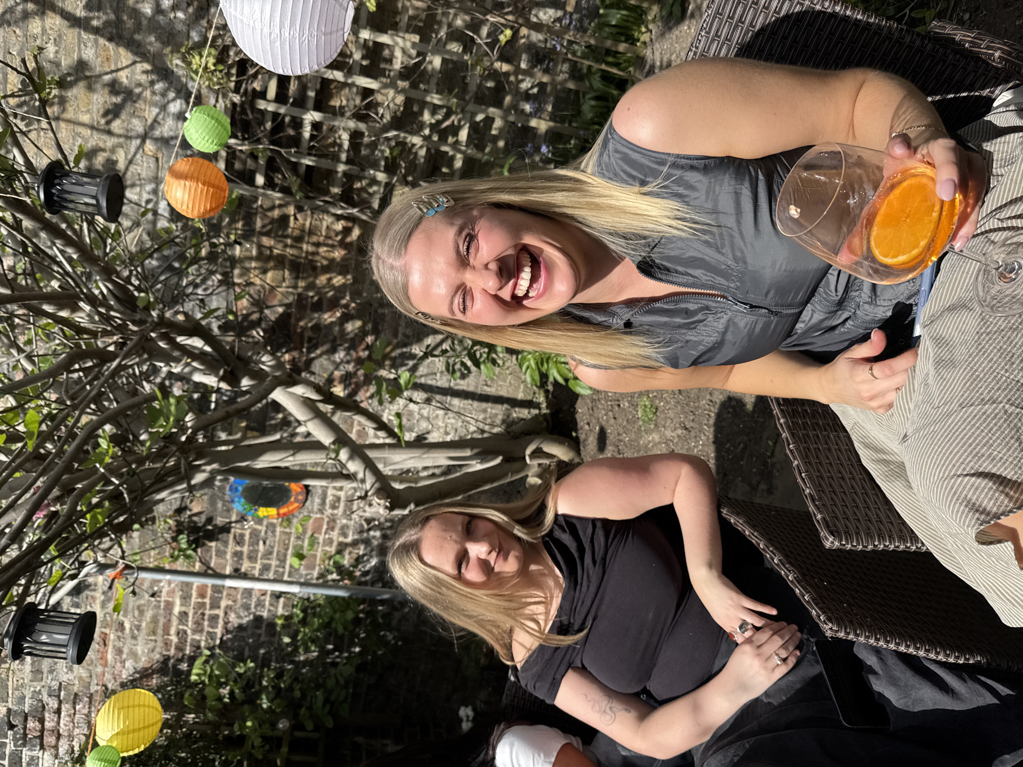 Two women enjoy sunny afternoon gathering in London garden