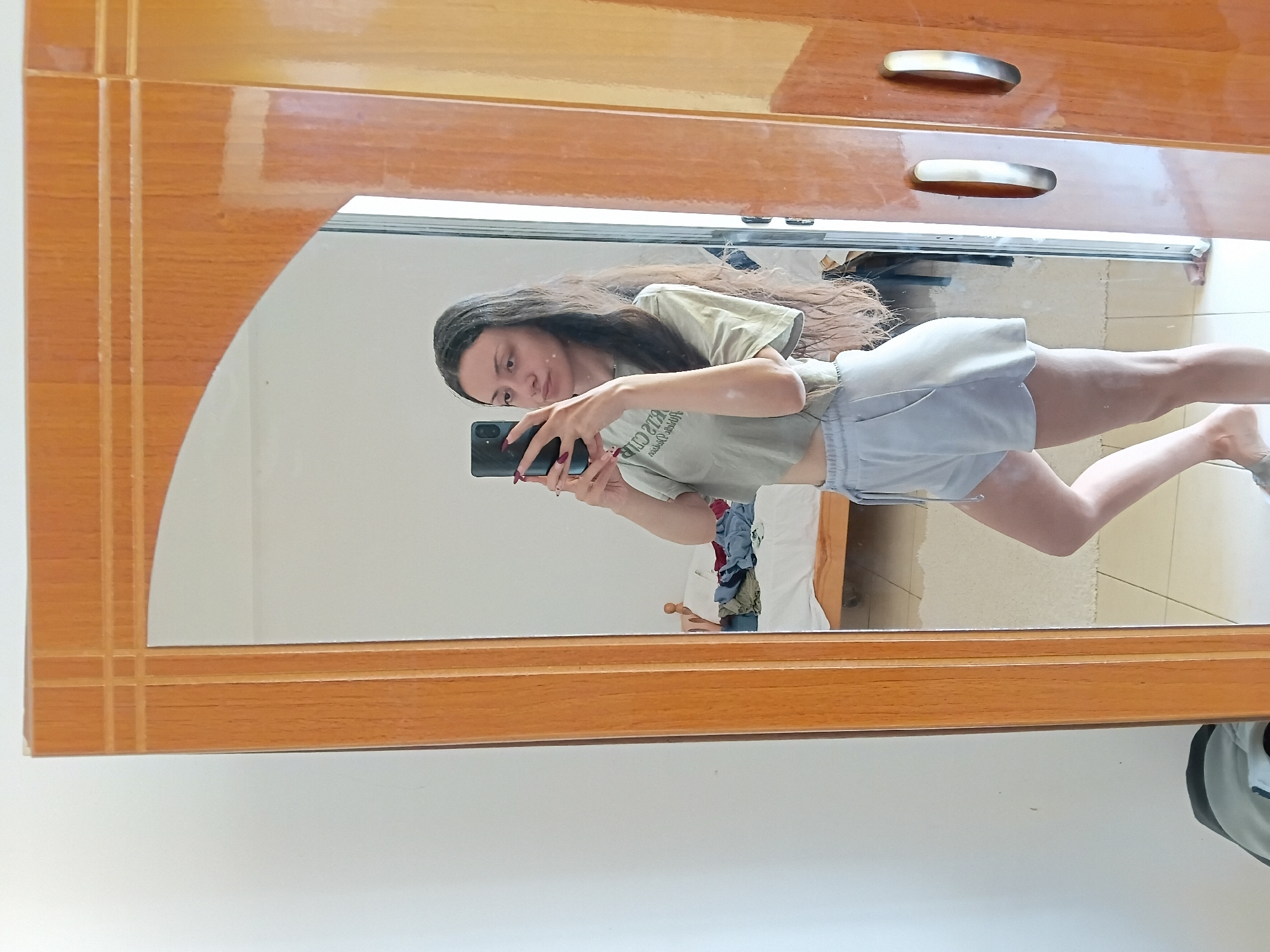 Woman takes mirror selfies in Vlora, Albania bedroom