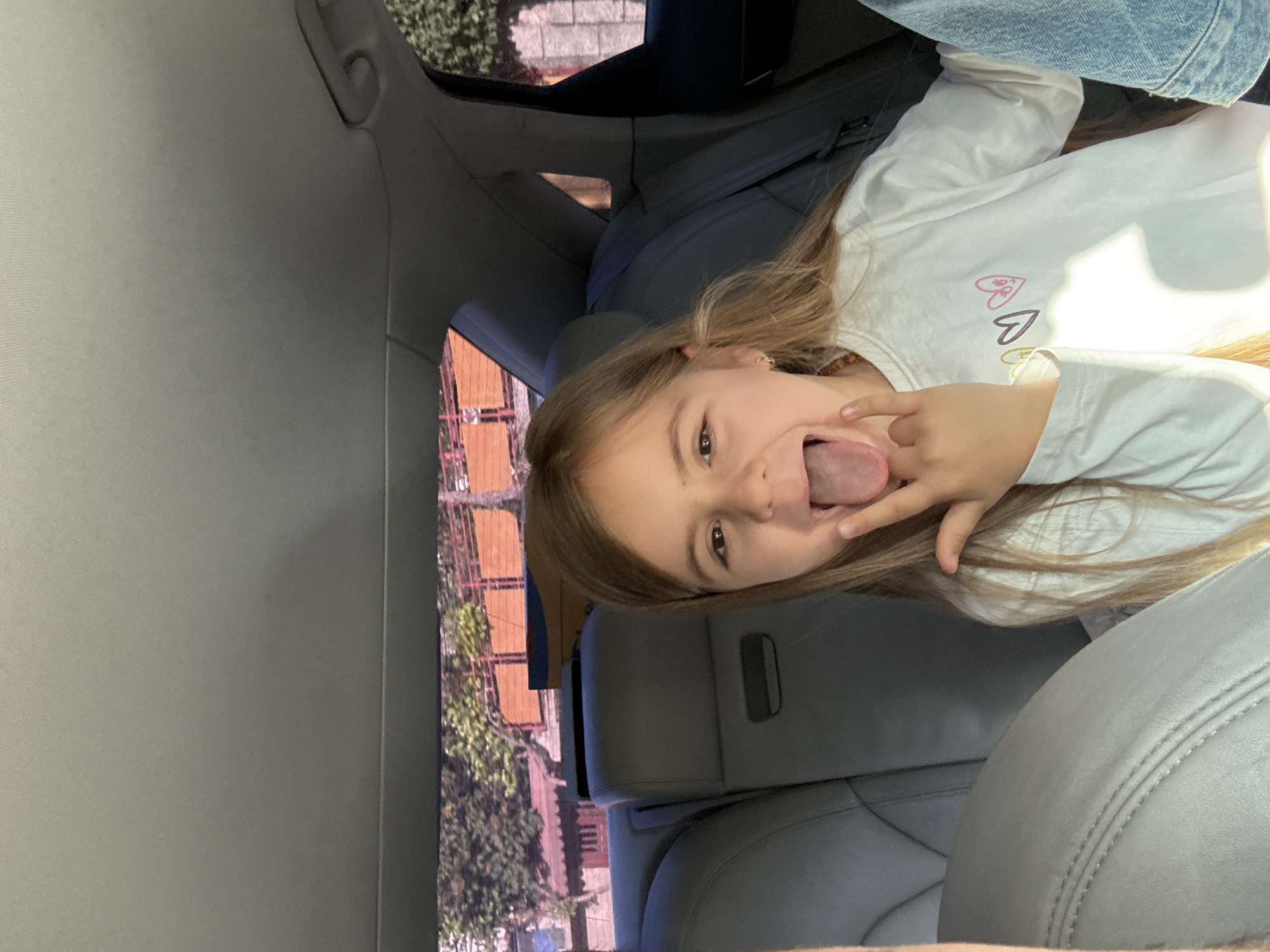 Girl makes playful gestures in car in Rila, Bulgaria