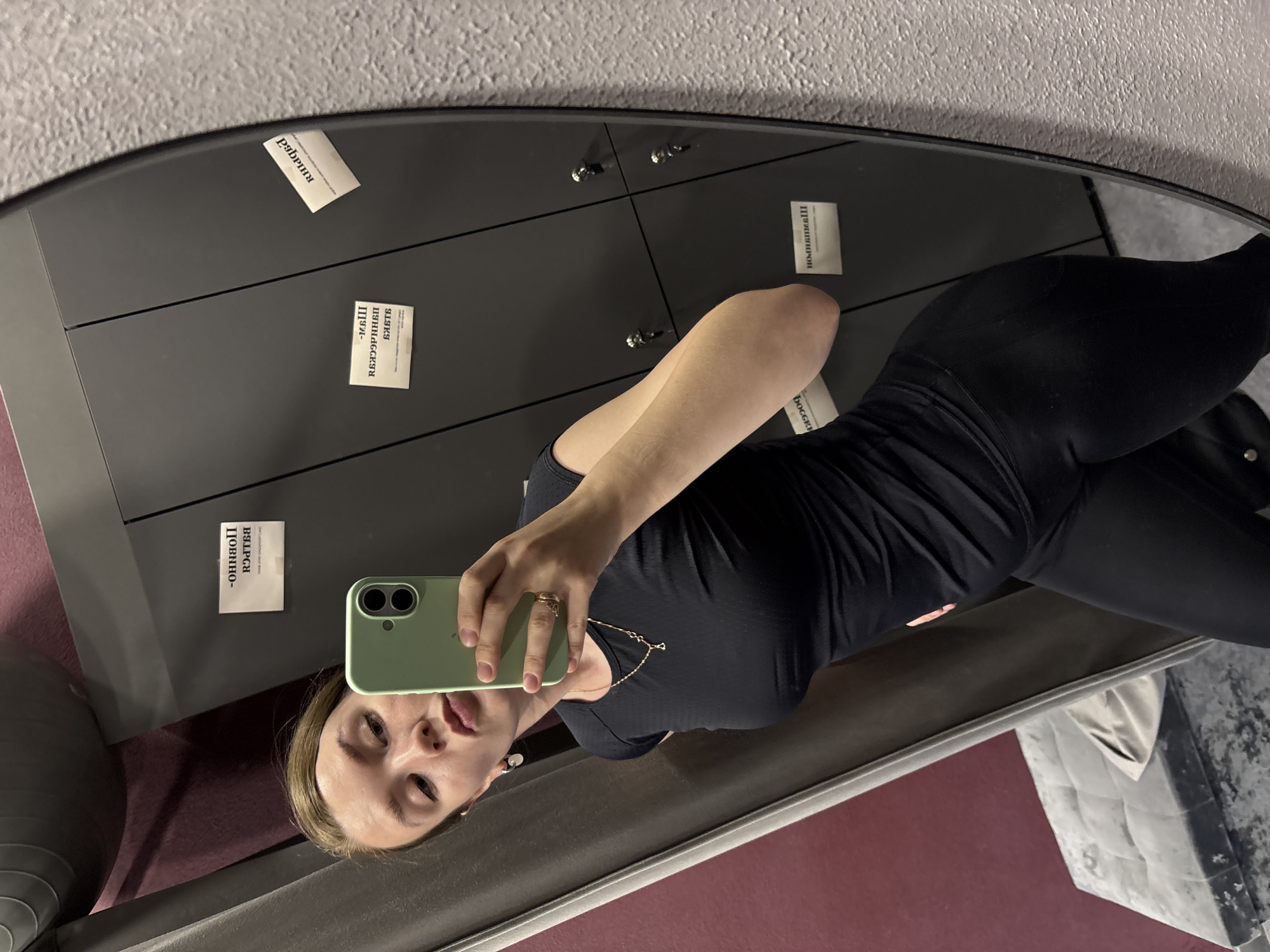 Woman takes mirror selfies with green phone in Izhevsk