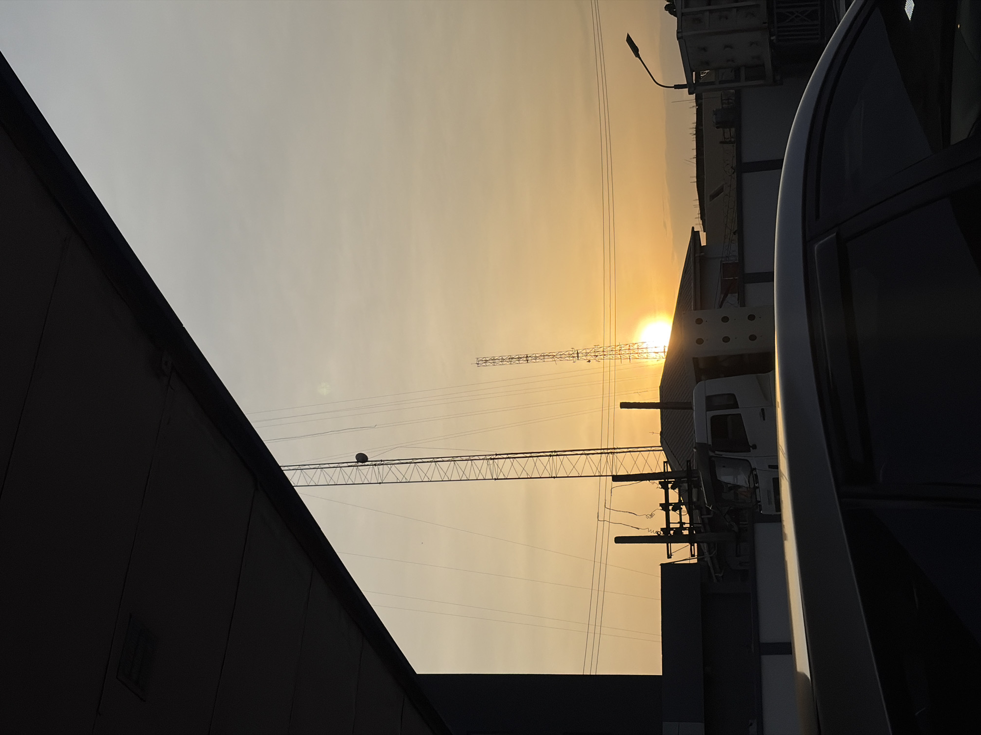 Construction cranes silhouetted against golden sunset in Lekki, Nigeria