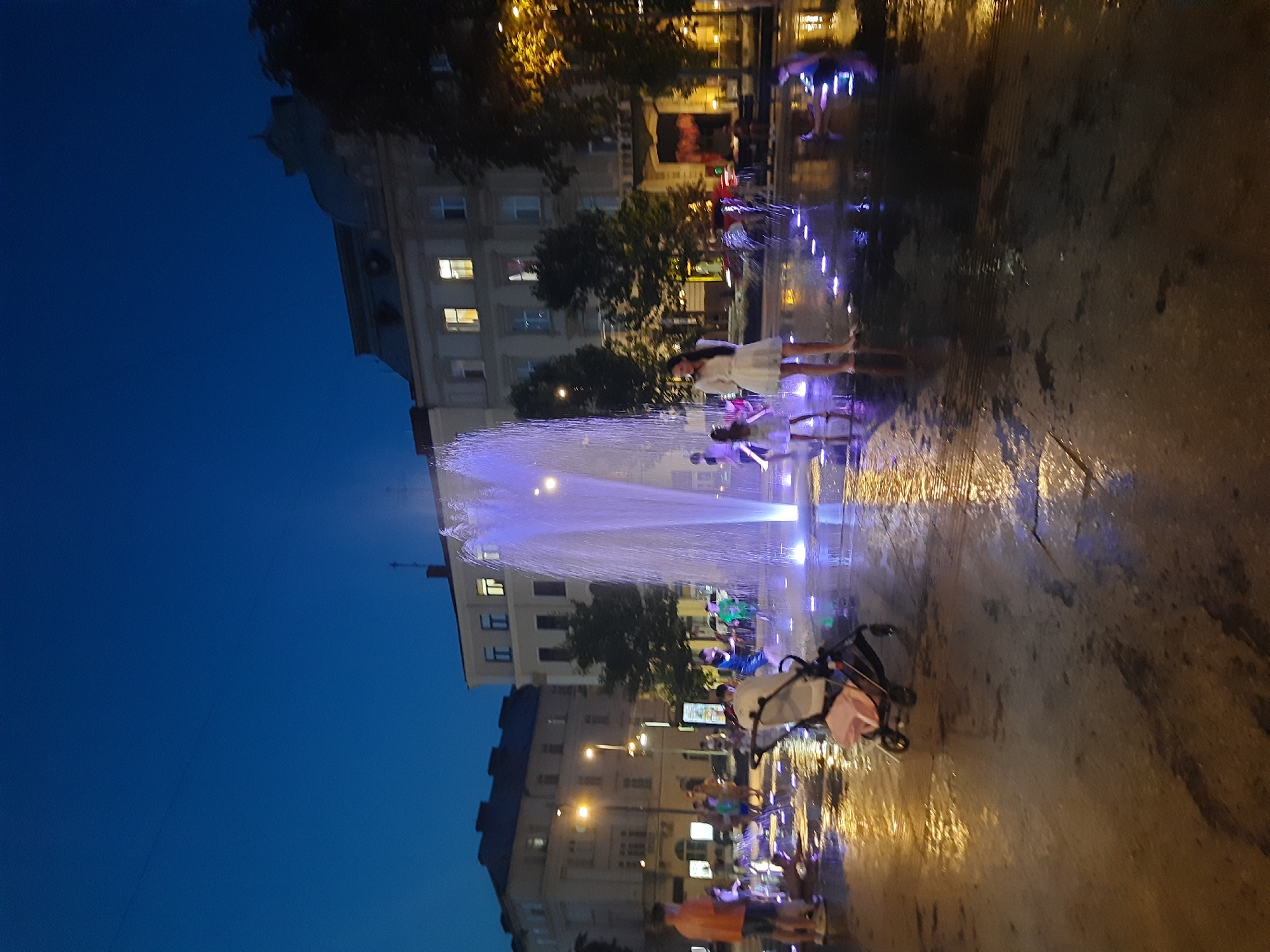 Lviv fountain glows purple and white at dusk