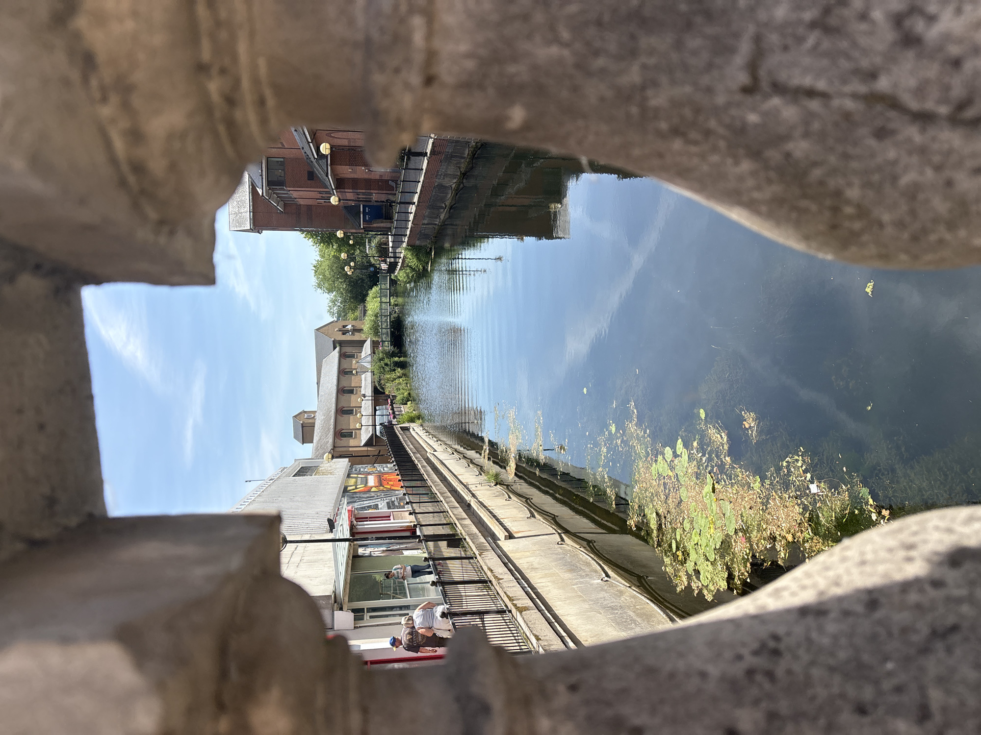 Sunny canal district: brick streets, murals, and midday foot traffic