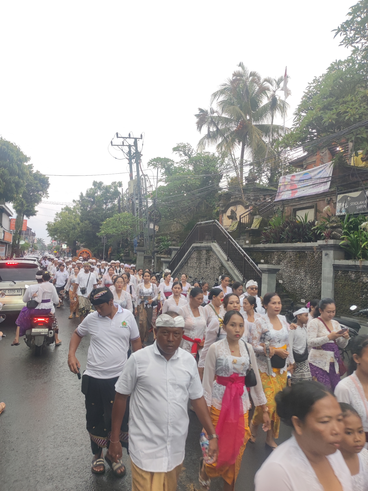 Traditional religious procession moves through wet Ubud streets