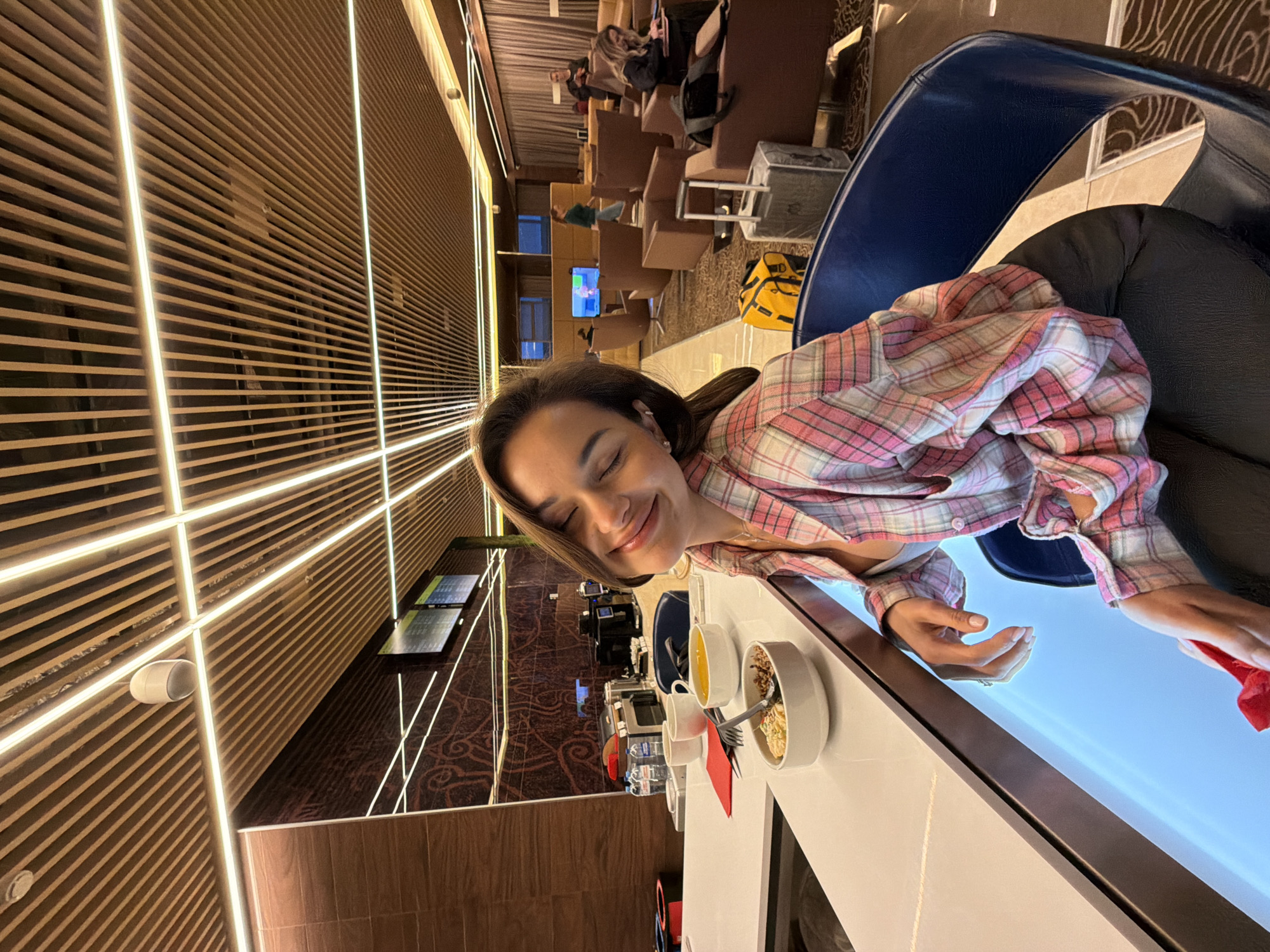 Woman in plaid shirt observed dining at airport lounge
