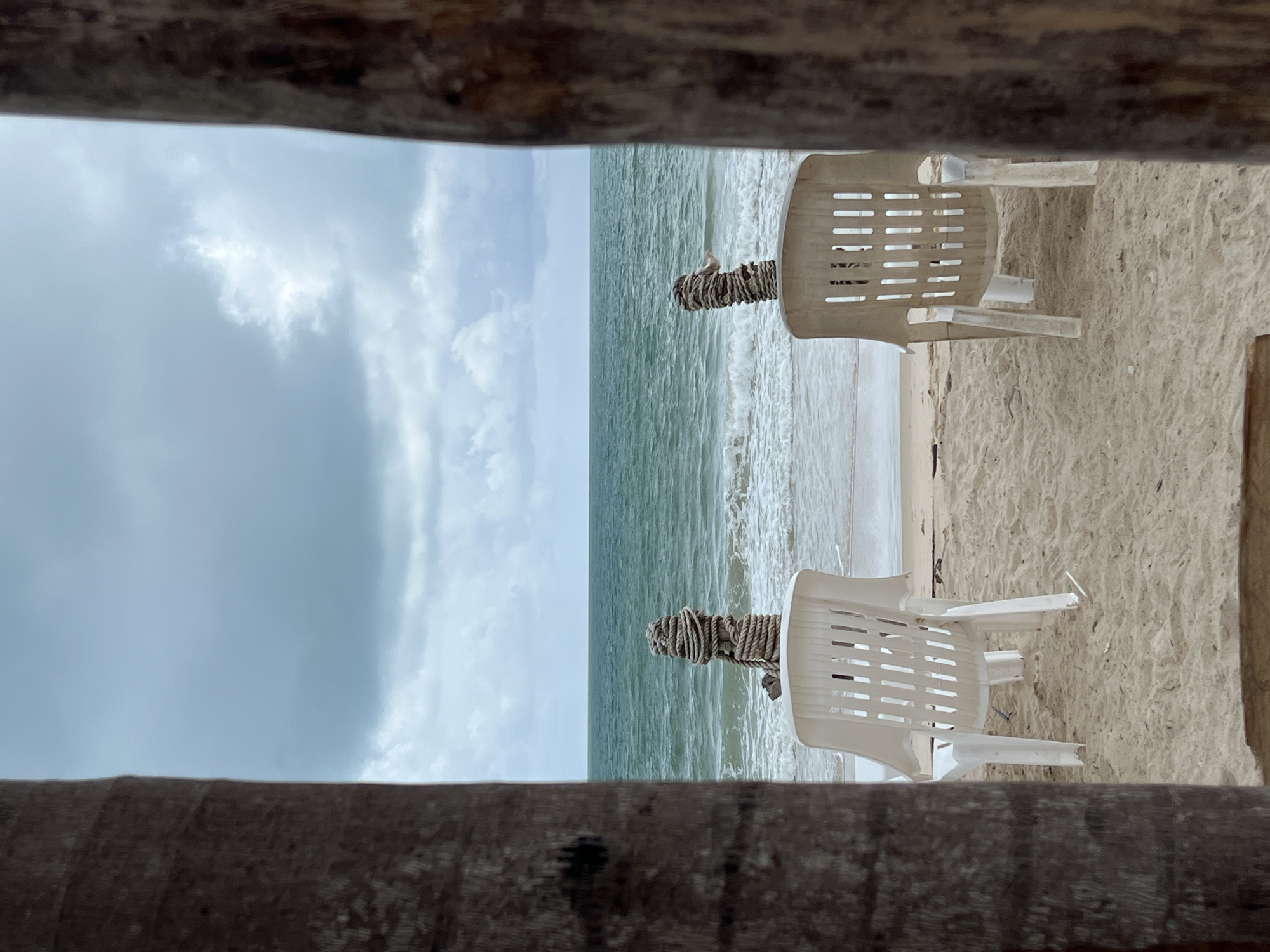 Beach morning setup captured with chairs and striped umbrella