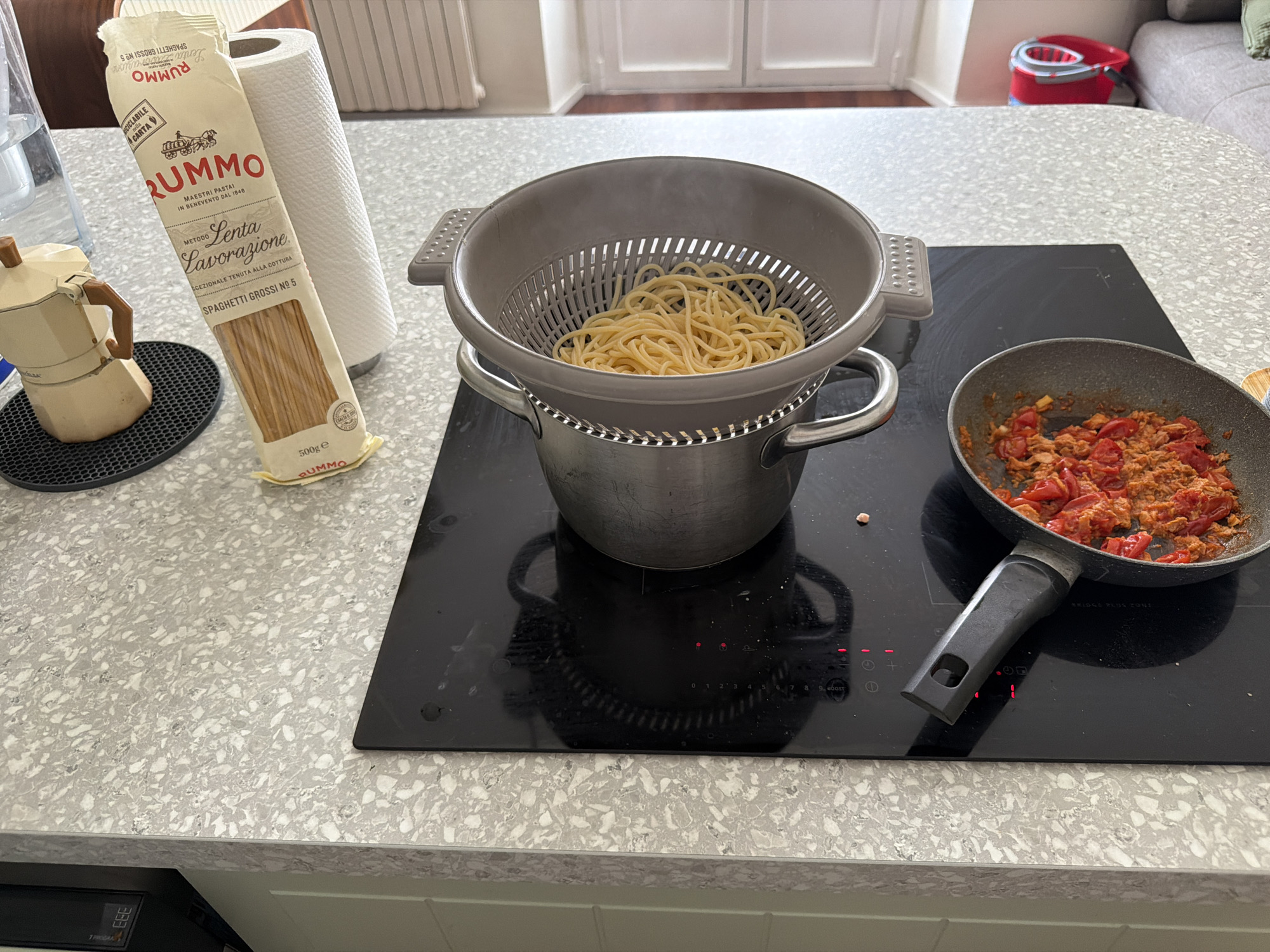 Spaghetti draining on a Milan kitchen cooktop