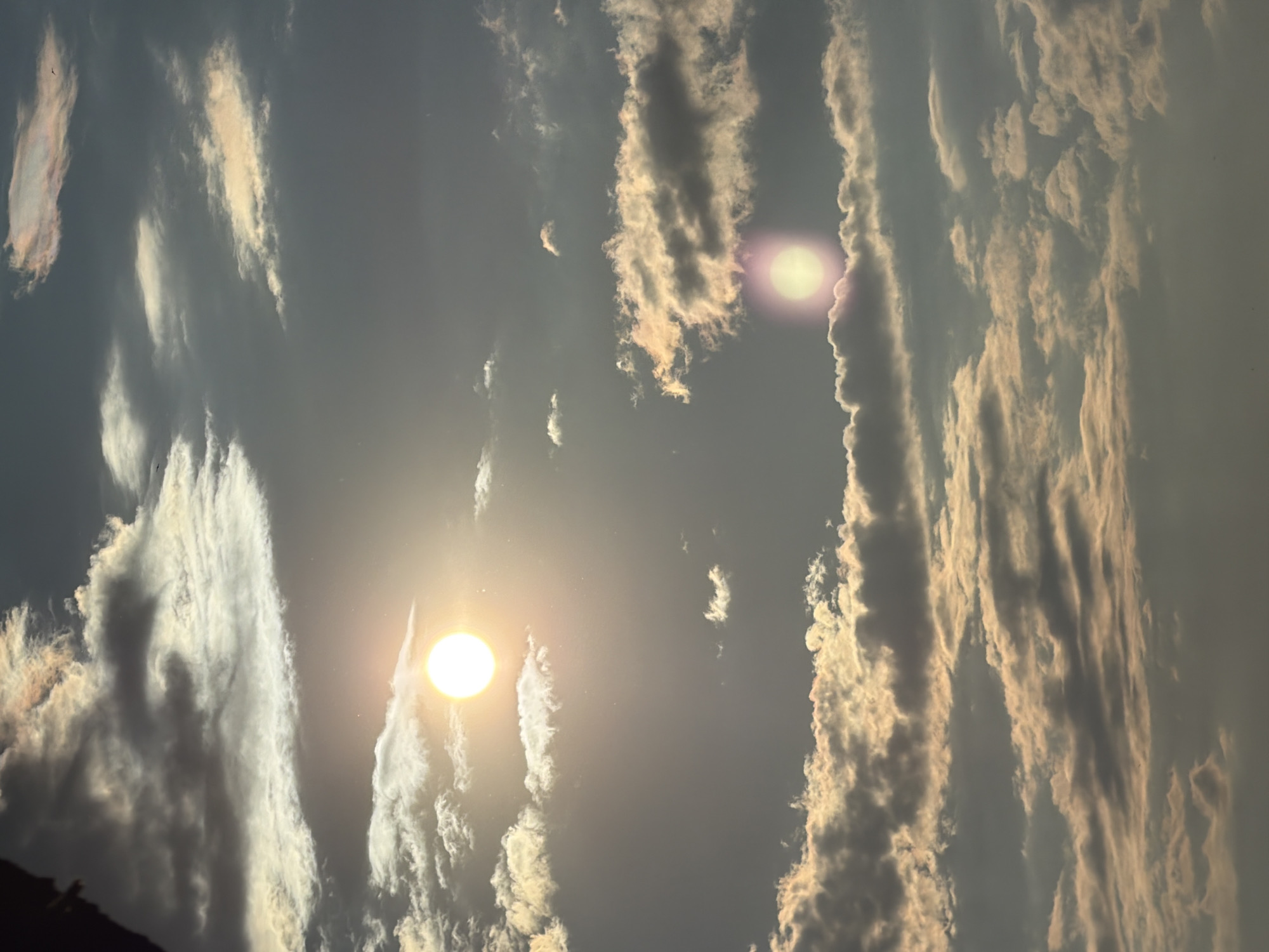 Witness Reports Two Bright Light Sources Among Mixed Clouds
