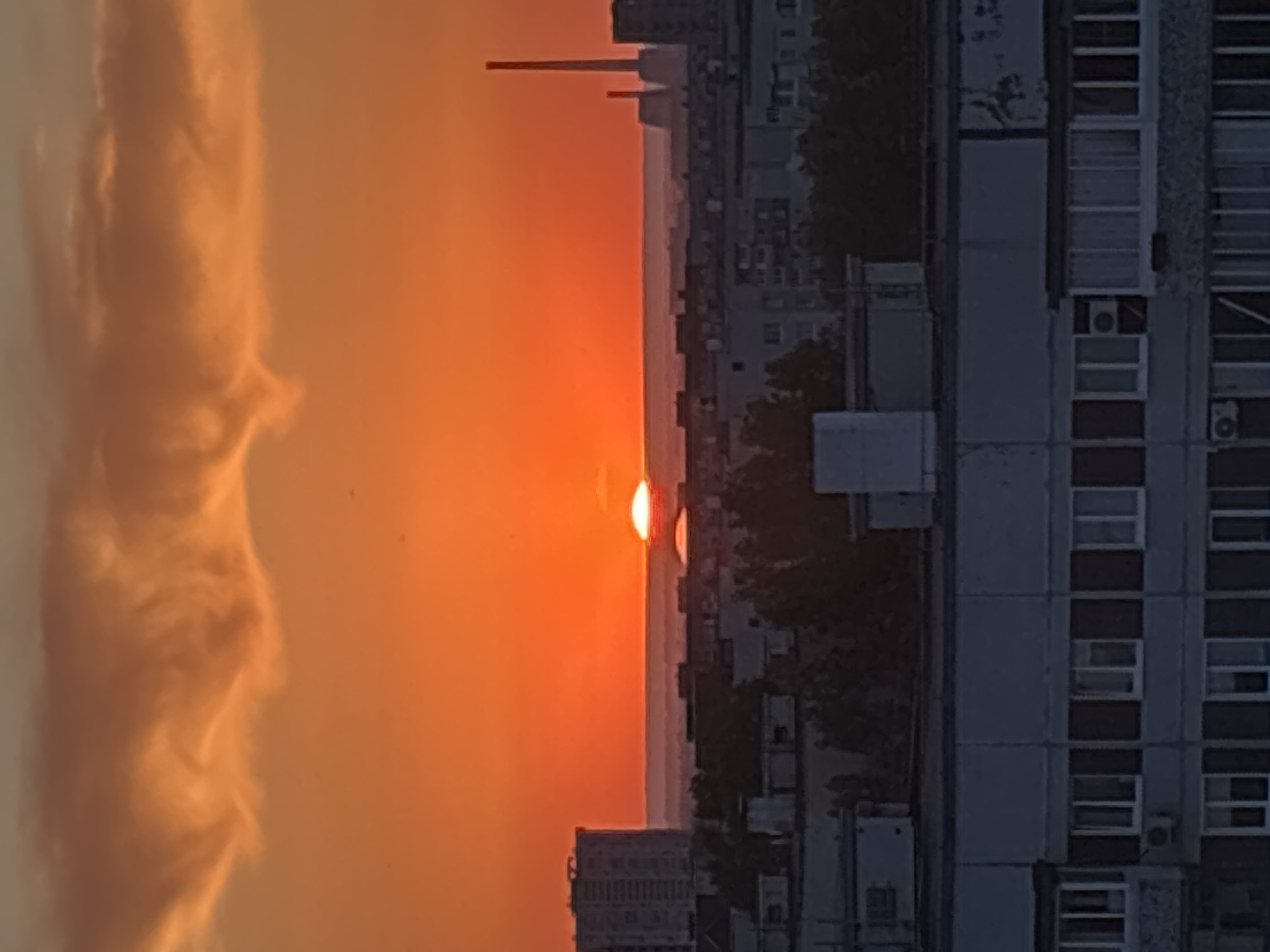 Urban sunset observed with orange skies behind city buildings