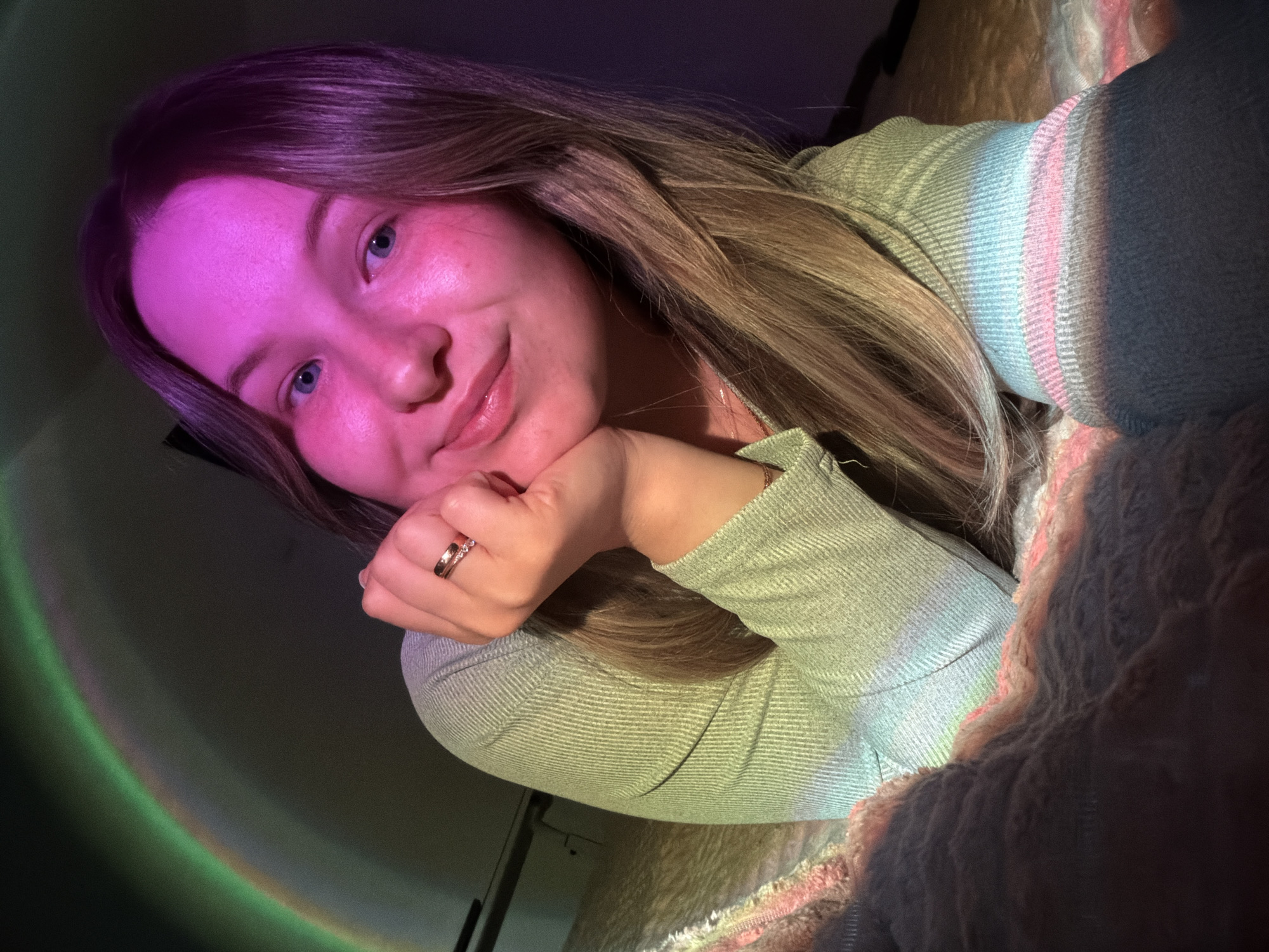 Woman rests on bed with rainbow light in Chaikovsky