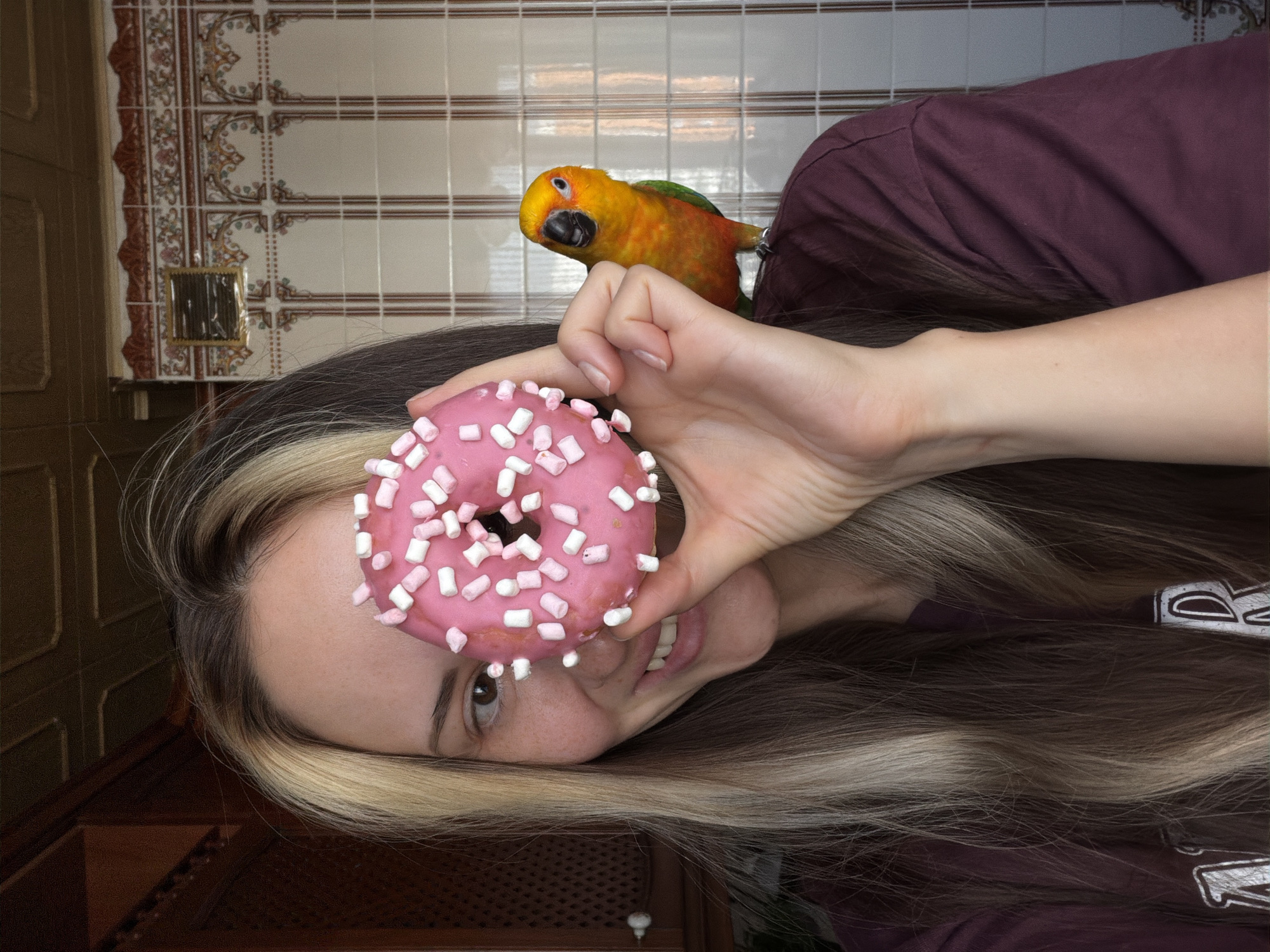 Woman poses with pet parrot and donut in Khimki