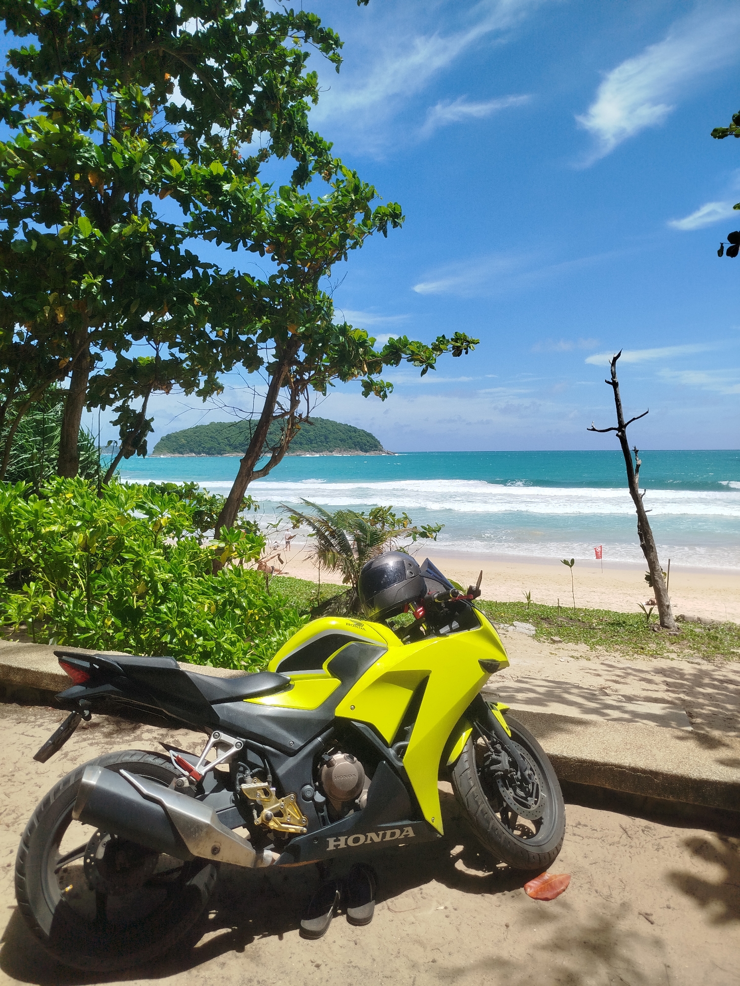 Yellow motorcycle parked beachside at Rawai on a sunny morning