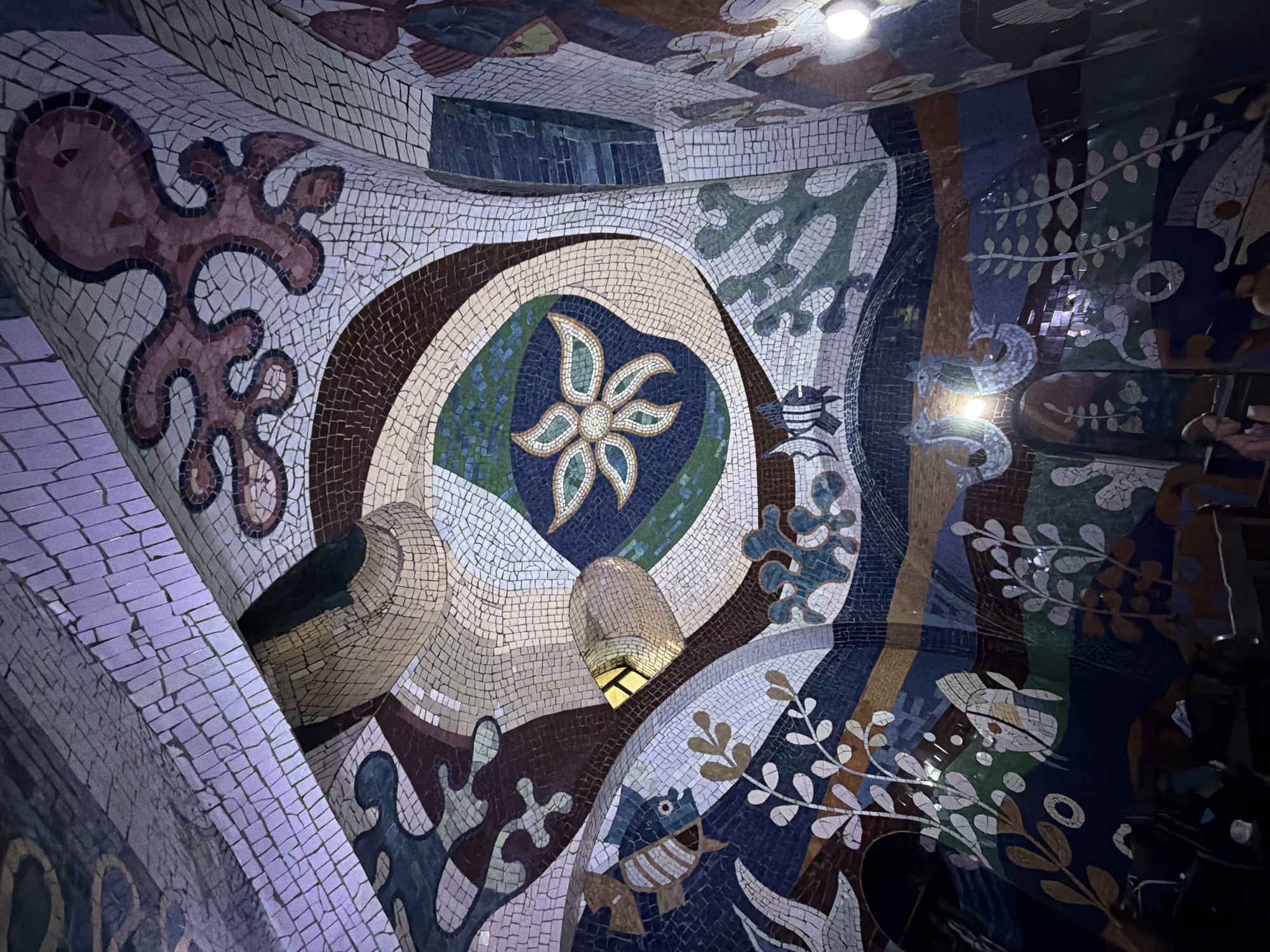 Visitor documents mosaic art and garden paths in Tbilisi