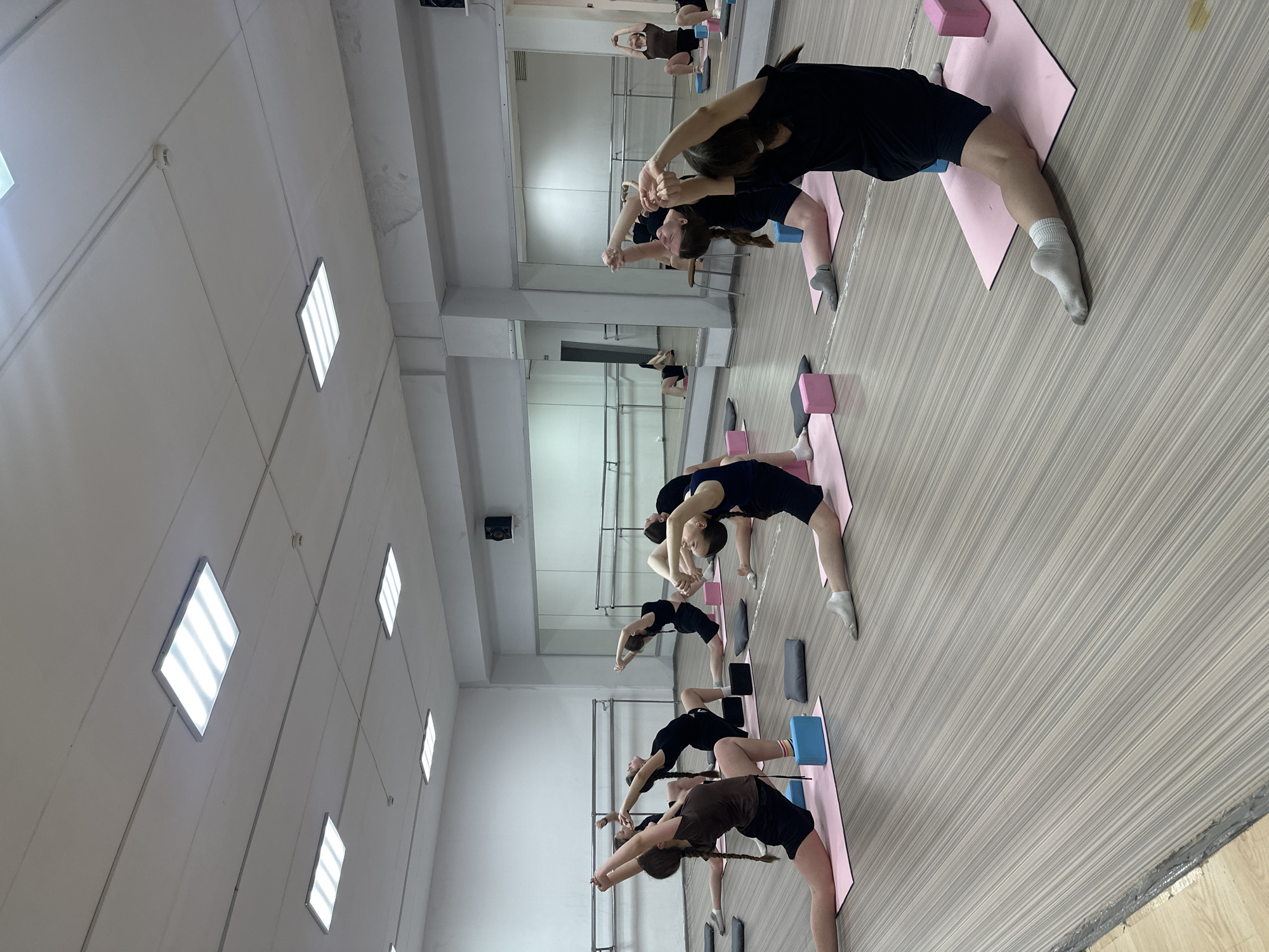 Three dancers perform synchronized leap in Votkinsk studio