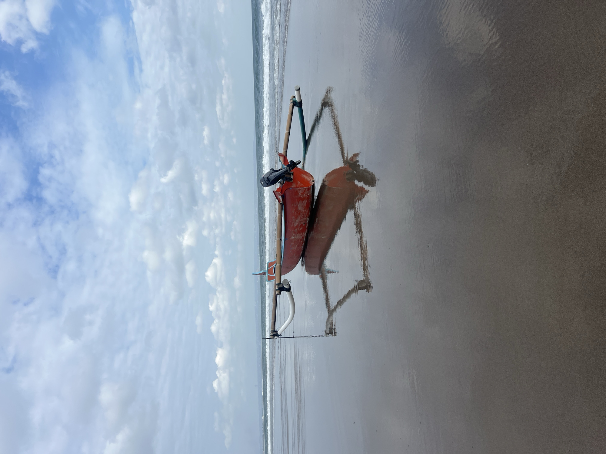 Red boat resting on the beach in North Kuta, Bali