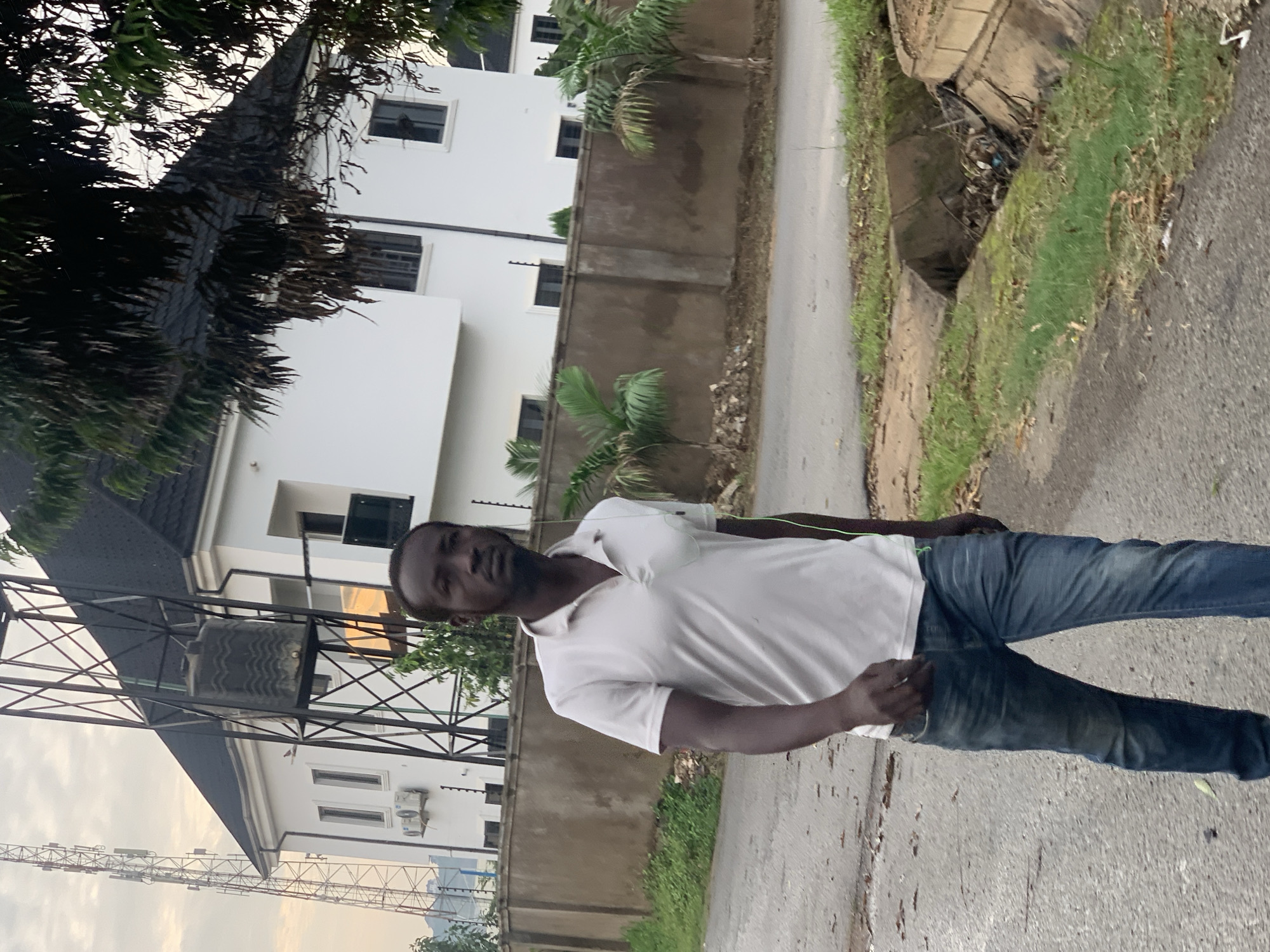 Wet morning street life in a residential Abuja neighborhood