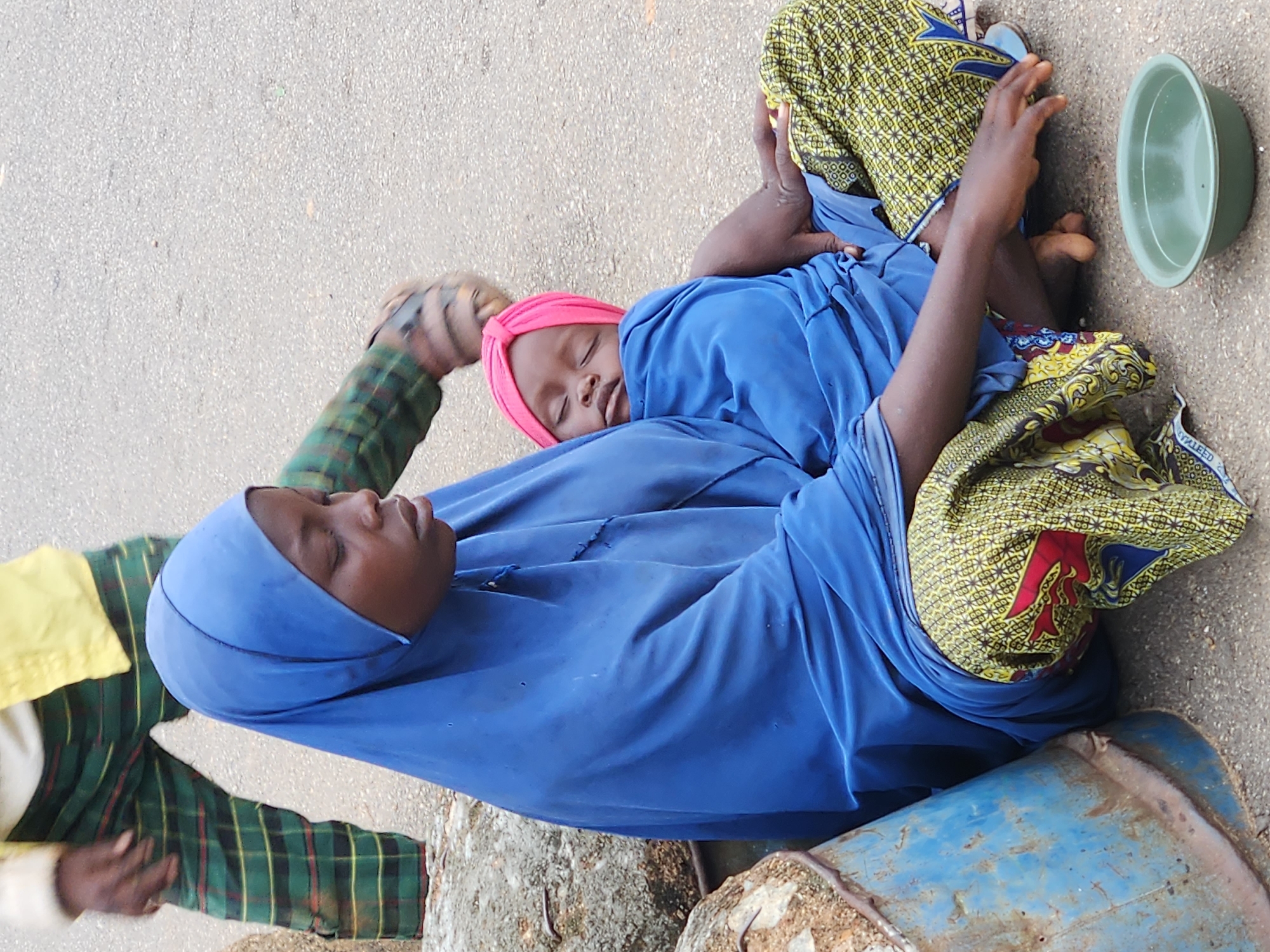 Street scenes captured showing women, infant, metal rod carriers