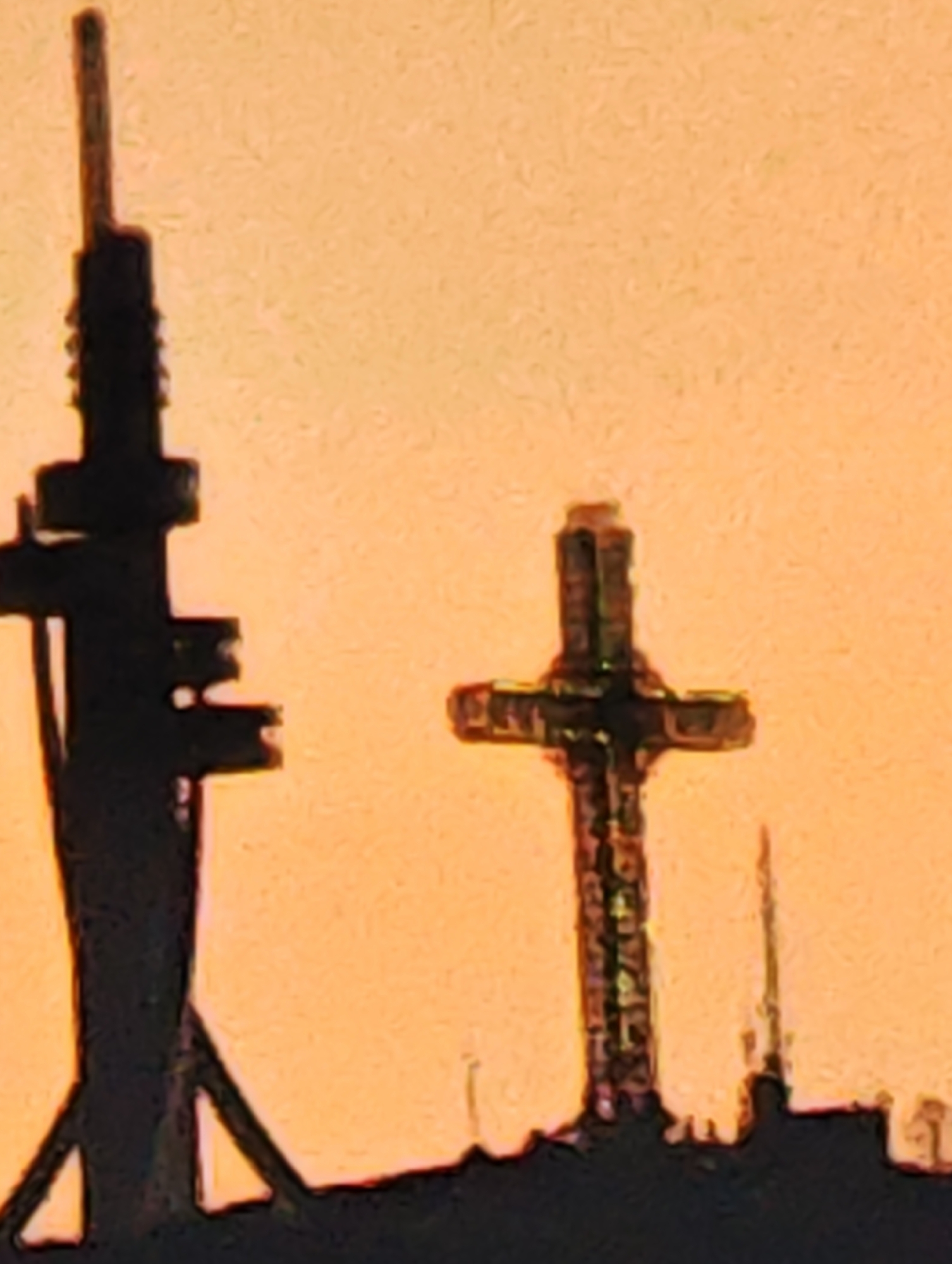 Sunset silhouettes telecommunications tower and cross in Skopje