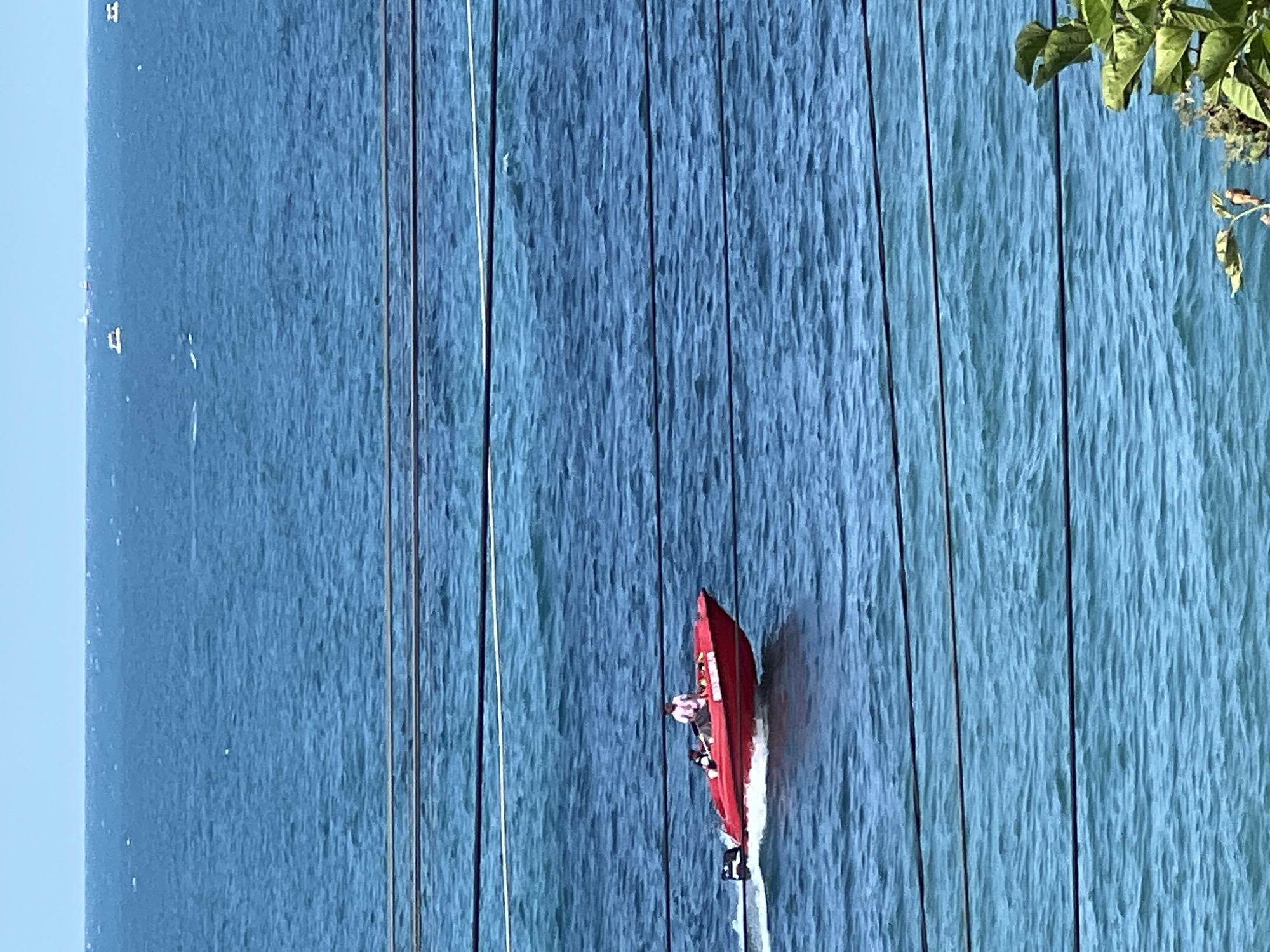 Red speedboat racing through choppy Black Sea waters near Sochi