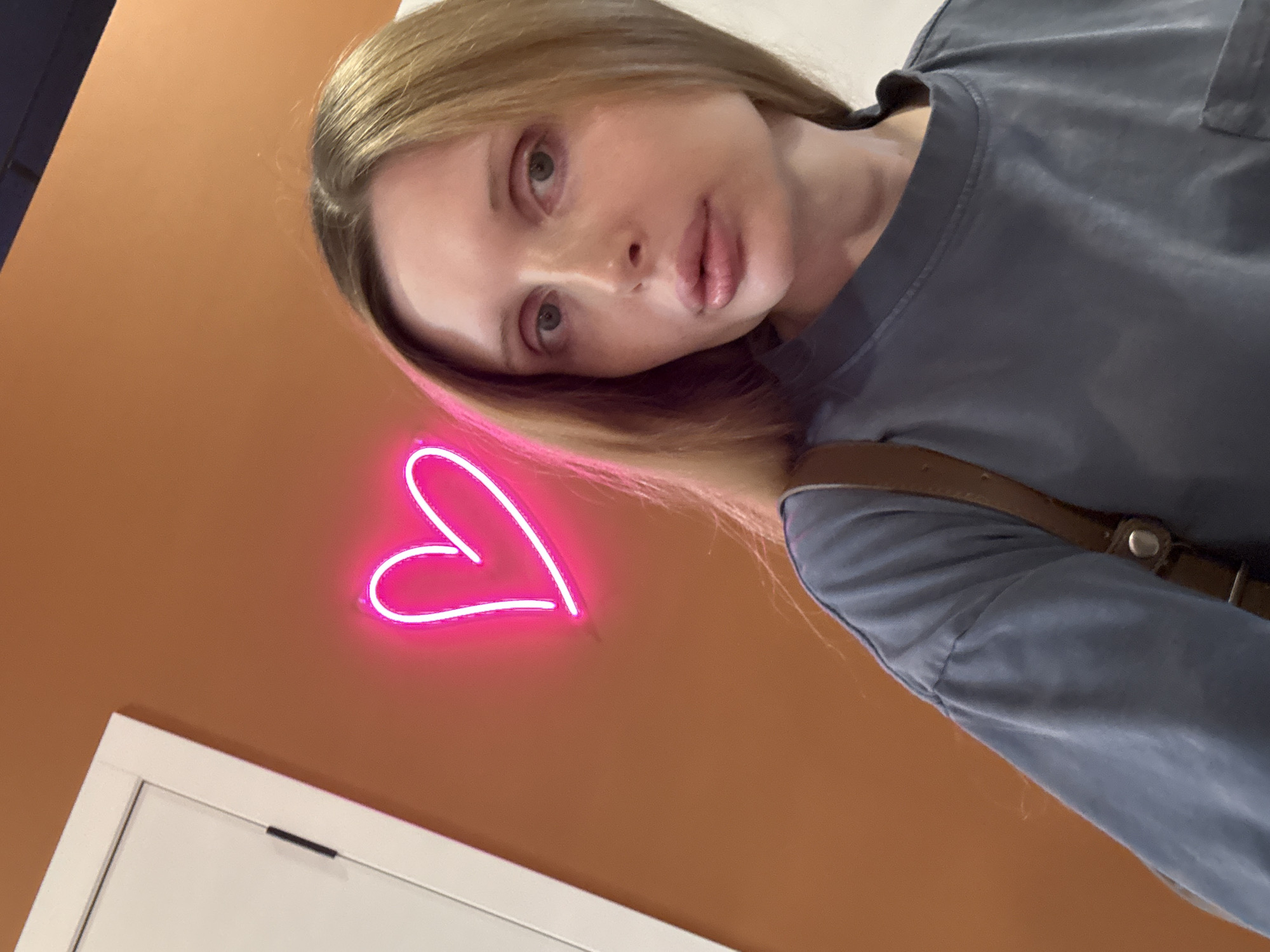 Selfie session around a pink neon heart sign