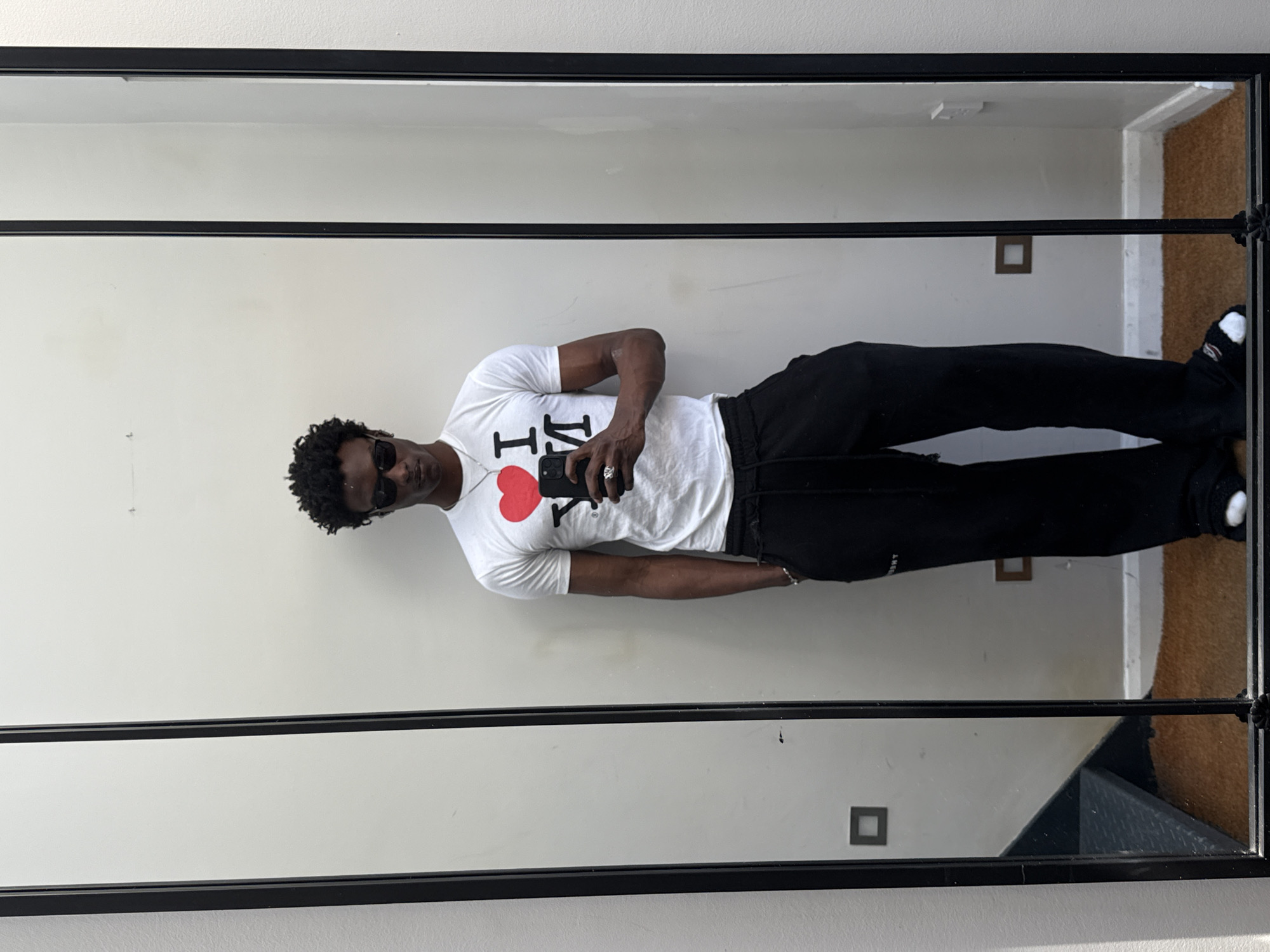 Tourist takes mirror selfie in London wearing NYC shirt