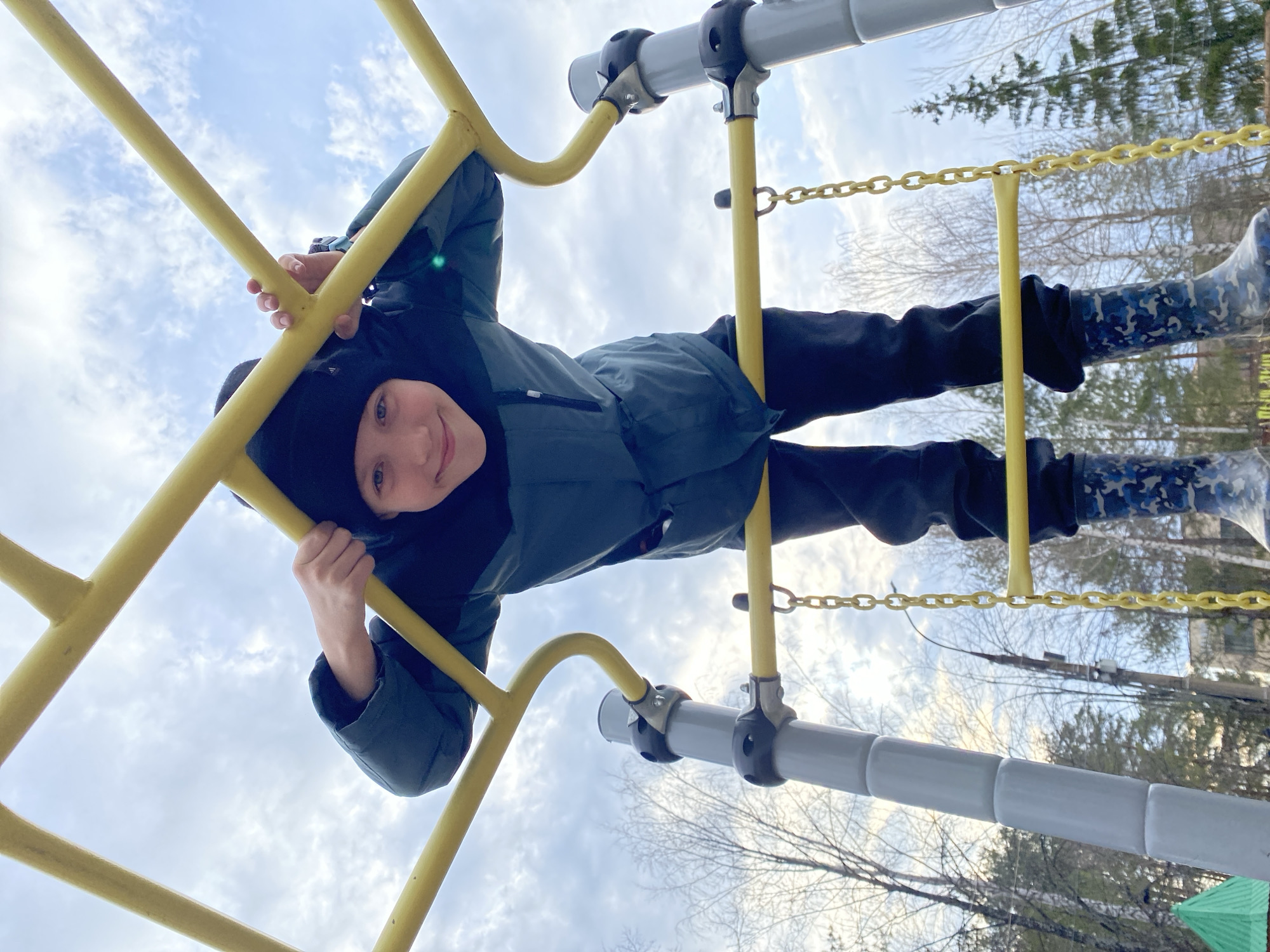 Child plays on playground equipment near Ferris wheel in Chaikovsky