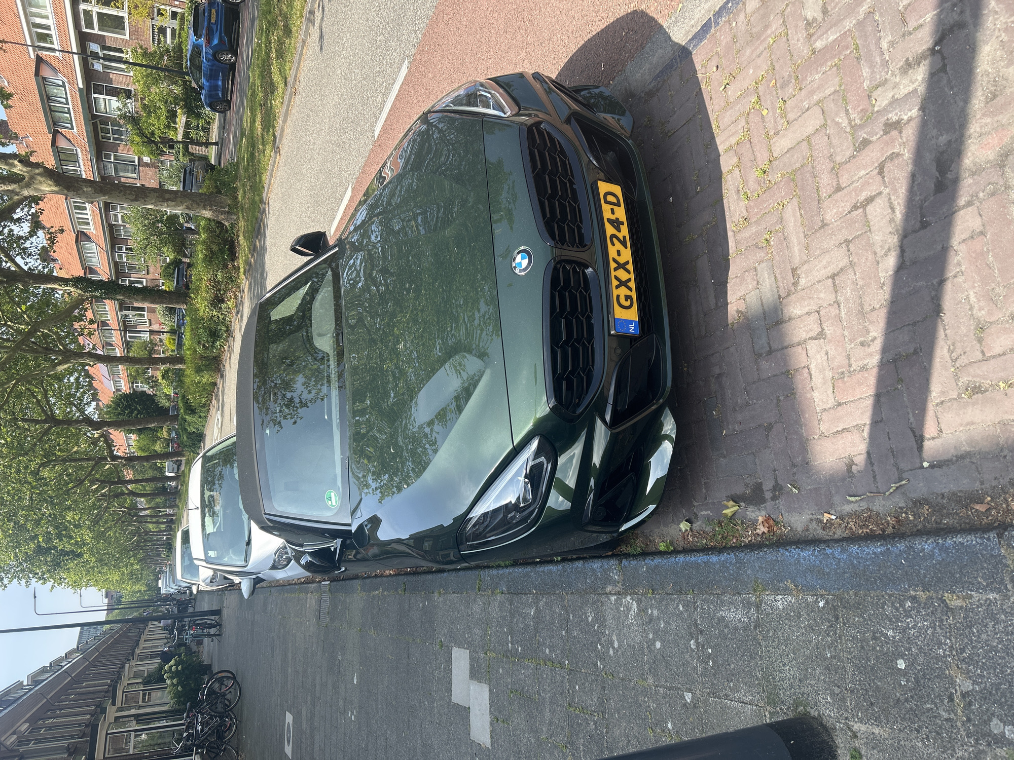 Parked BMW and historic orphan statue in Leiden streets