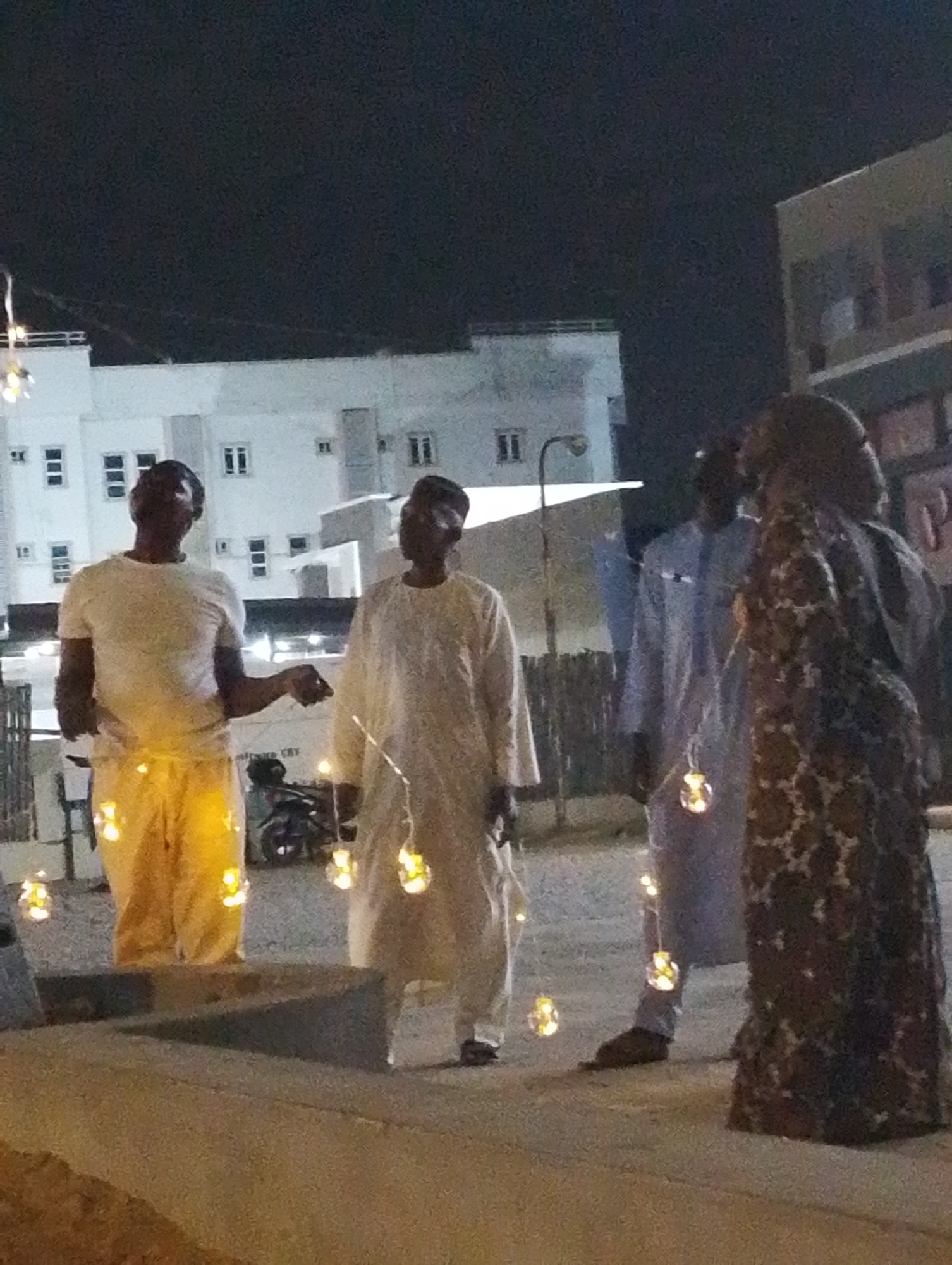 Nighttime gathering of people in Gandu Albasa, Nigeria