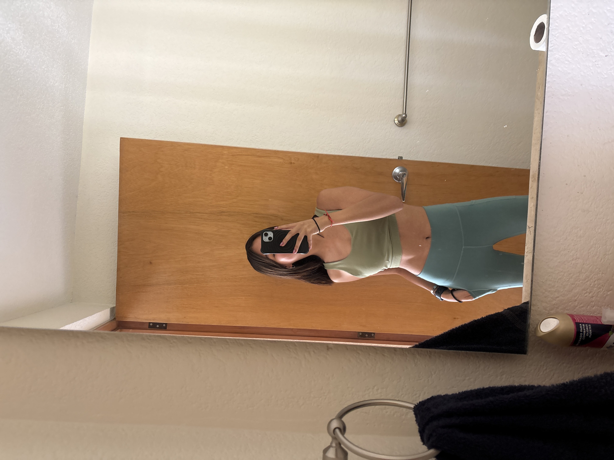 Person takes bathroom mirror selfie in athletic wear, Puebla