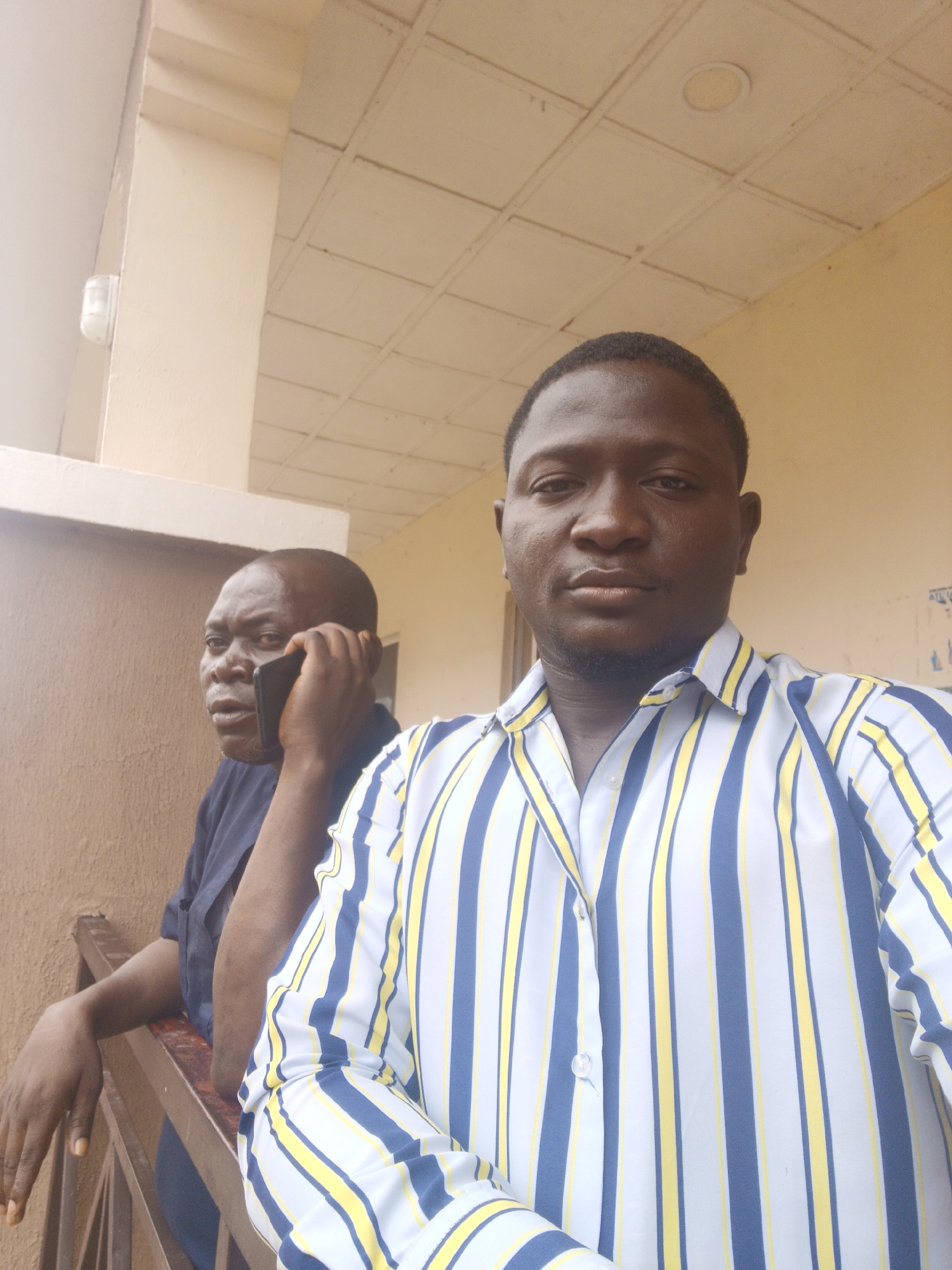 Two men photographed on balcony in Akwanga, Nigeria
