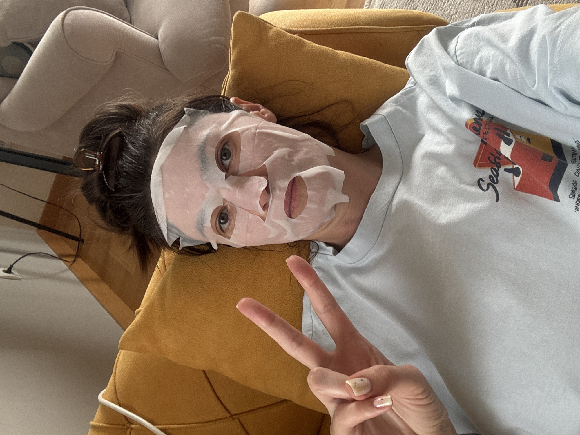 Woman enjoys skincare routine on couch in Podgorica