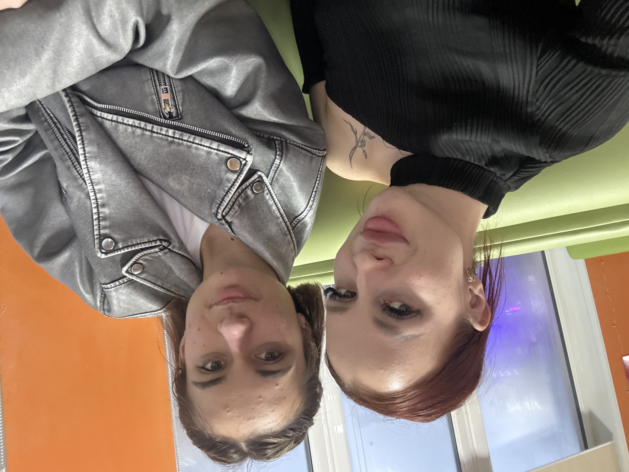 Two women pose for photos indoors in Simferopol