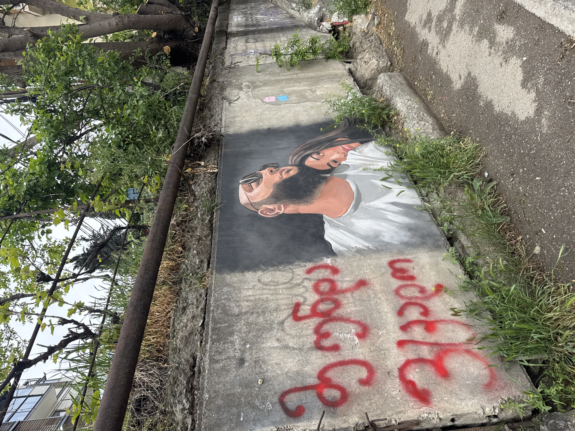 Woman takes selfies near street mural in Tbilisi
