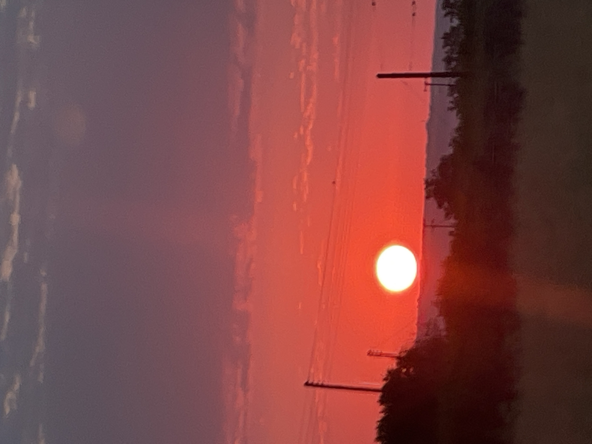 Wide sunset sky transitions from blue-green to deep red