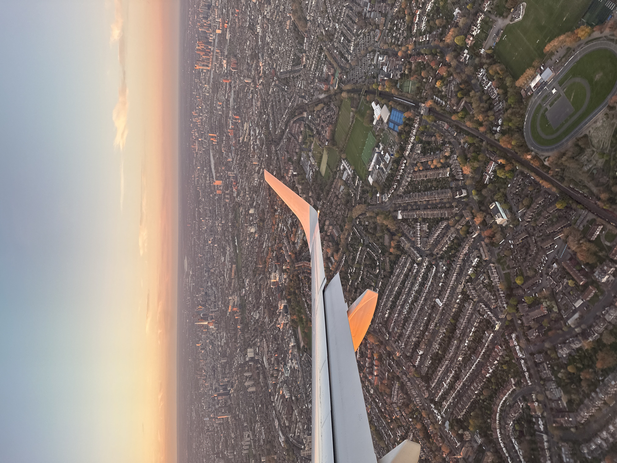 Aircraft passenger captures aerial dawn view over dense London neighborhoods