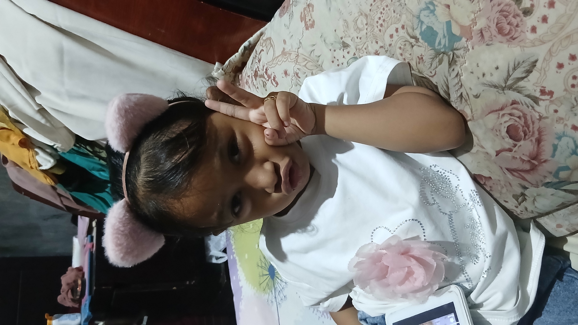 Portrait in white embellished tee with pink flower detail, Indonesia