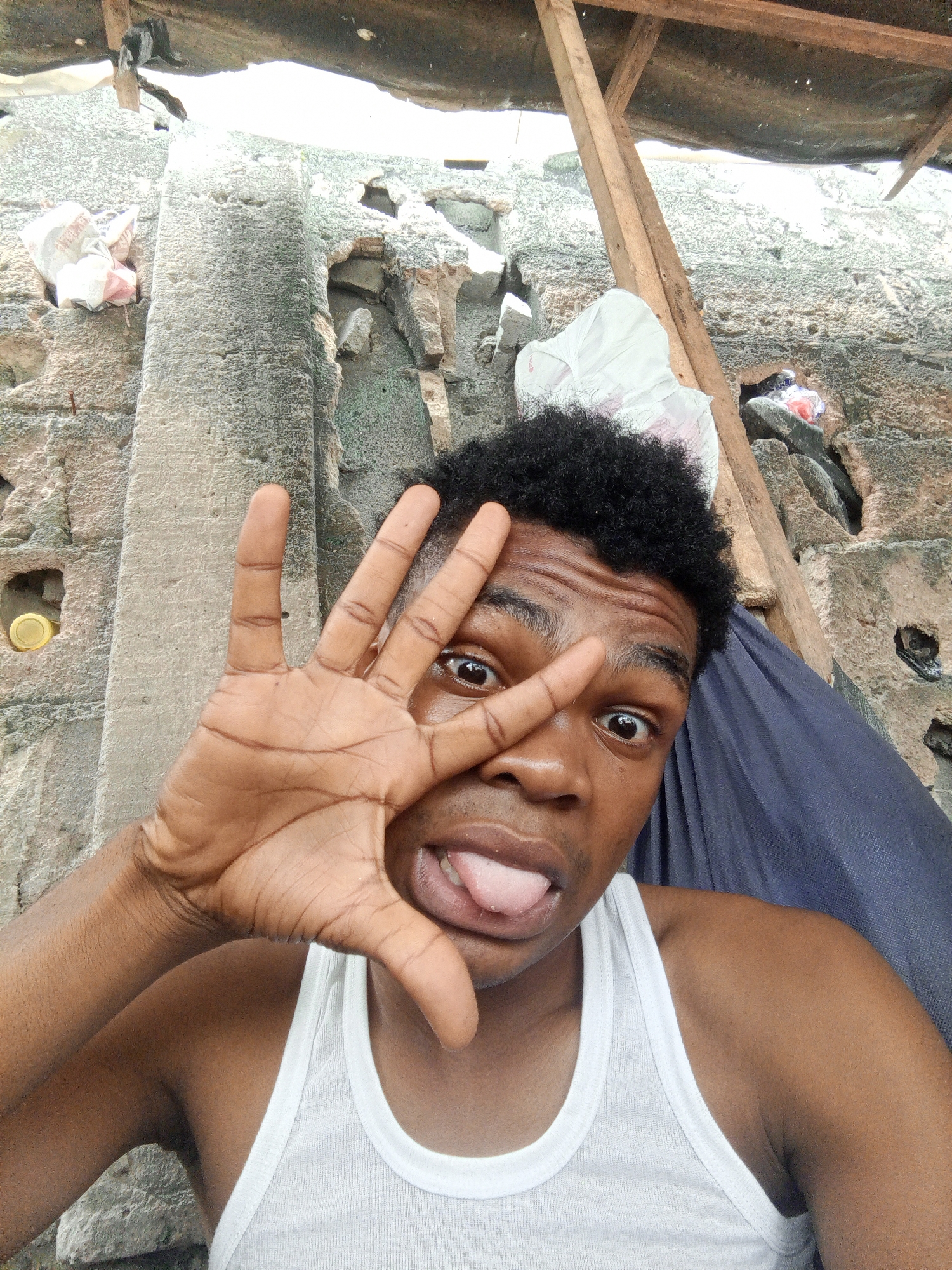 Casual selfie session against a stone wall in Ilado, Nigeria